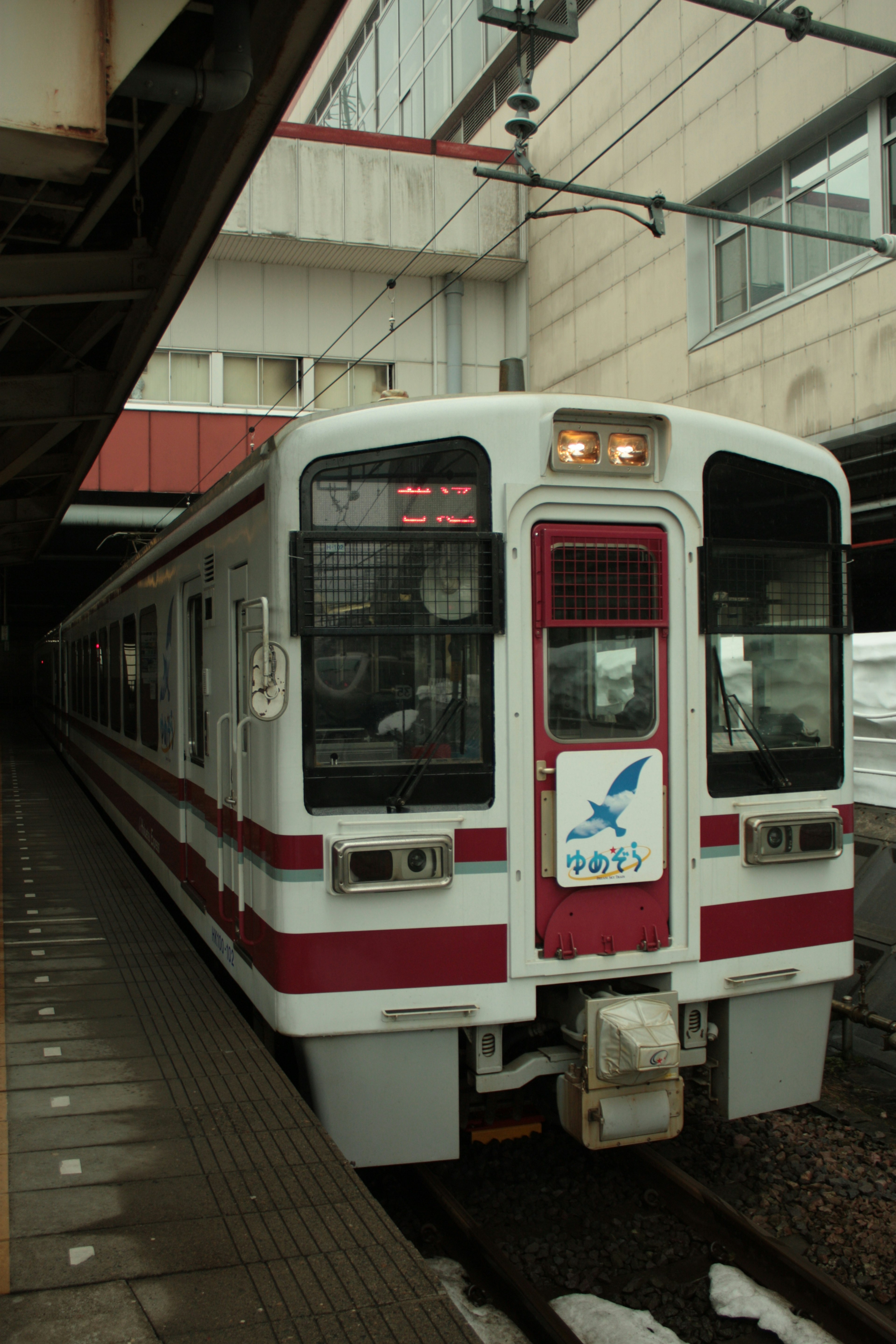 赤と白の電車が駅に停車している景色