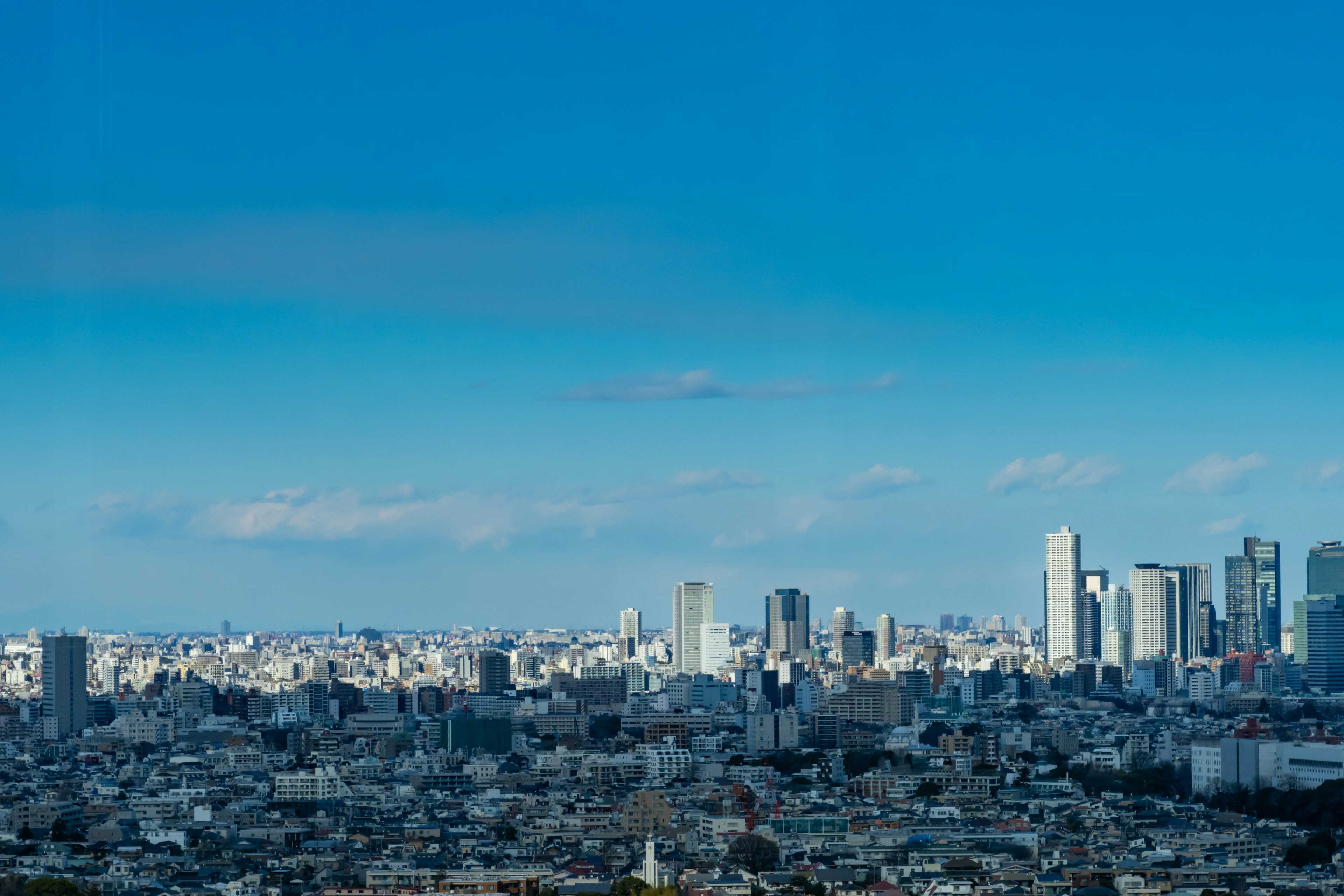 Stadtansicht unter einem blauen Himmel mit einer Mischung aus Wolkenkratzern und Wohngebieten