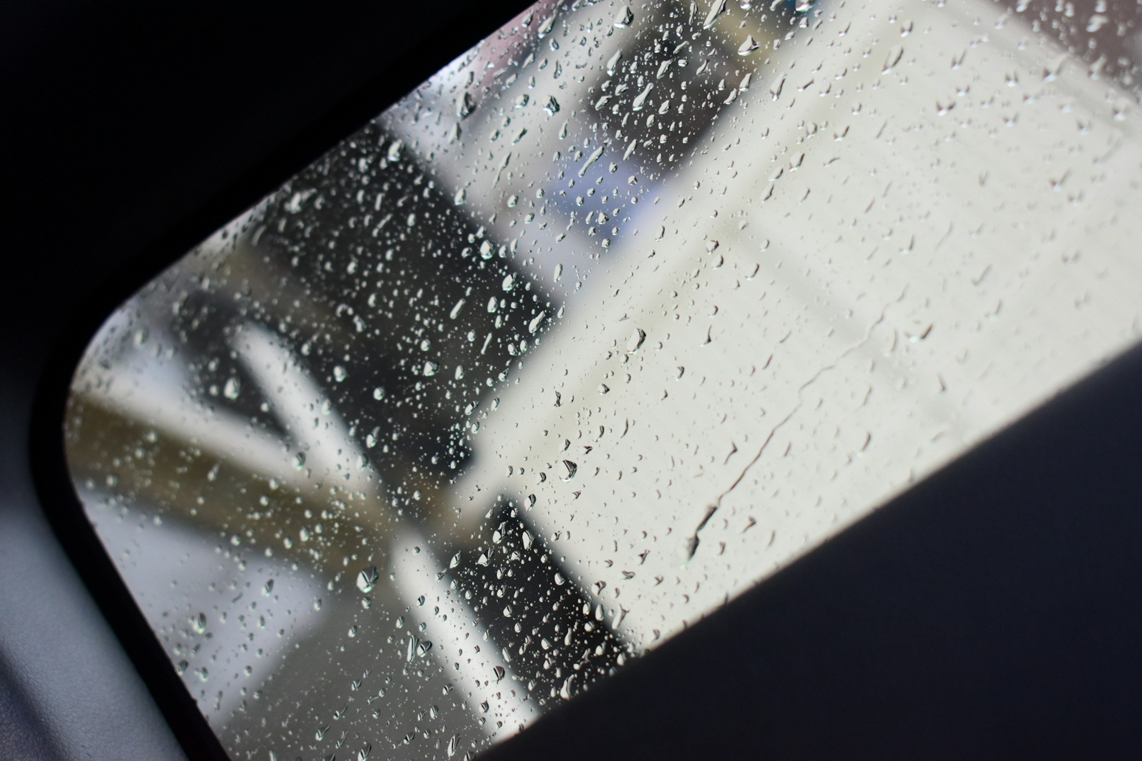 Ventana con gotas de lluvia mostrando una vista borrosa al exterior