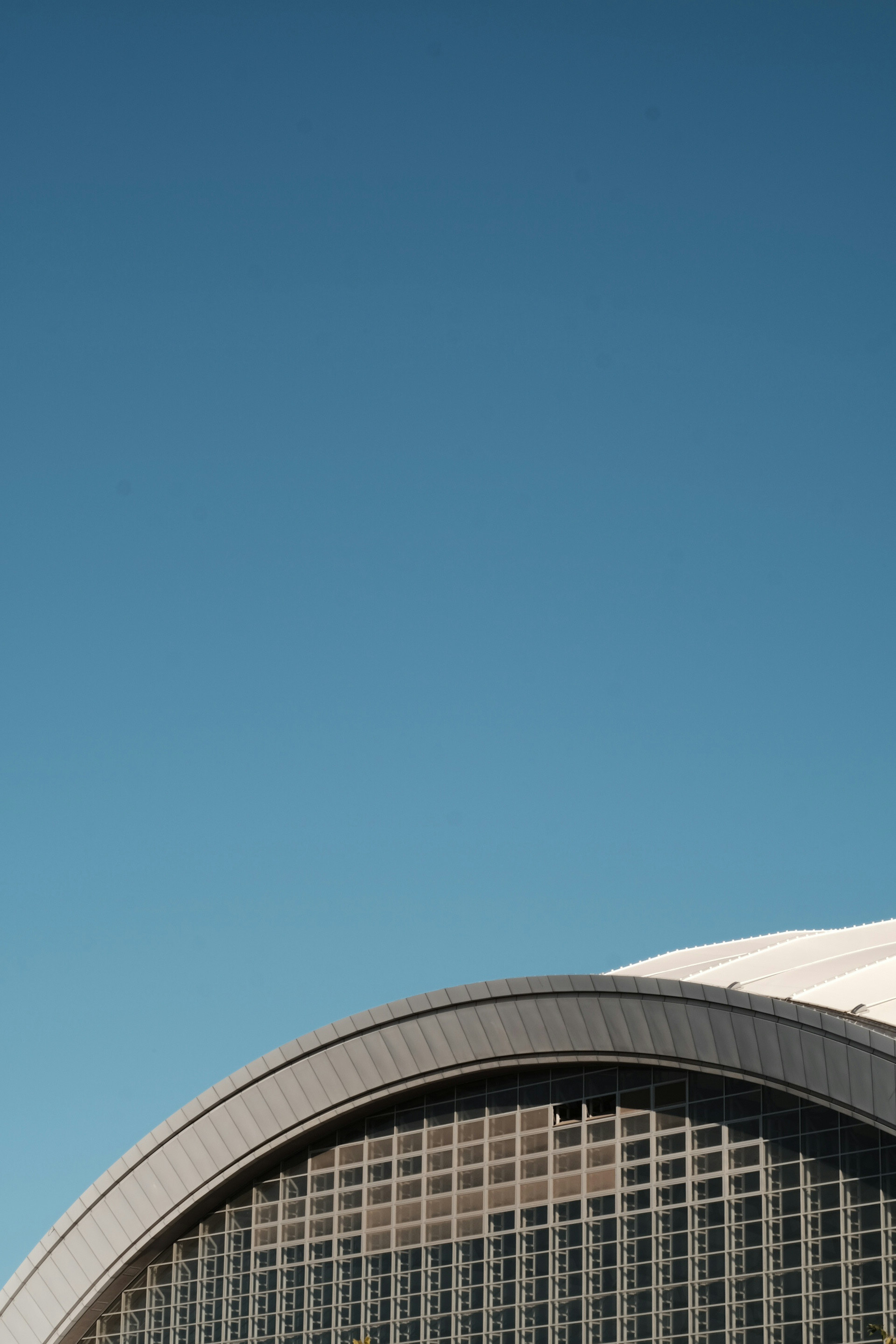 Modern building arch under a clear blue sky