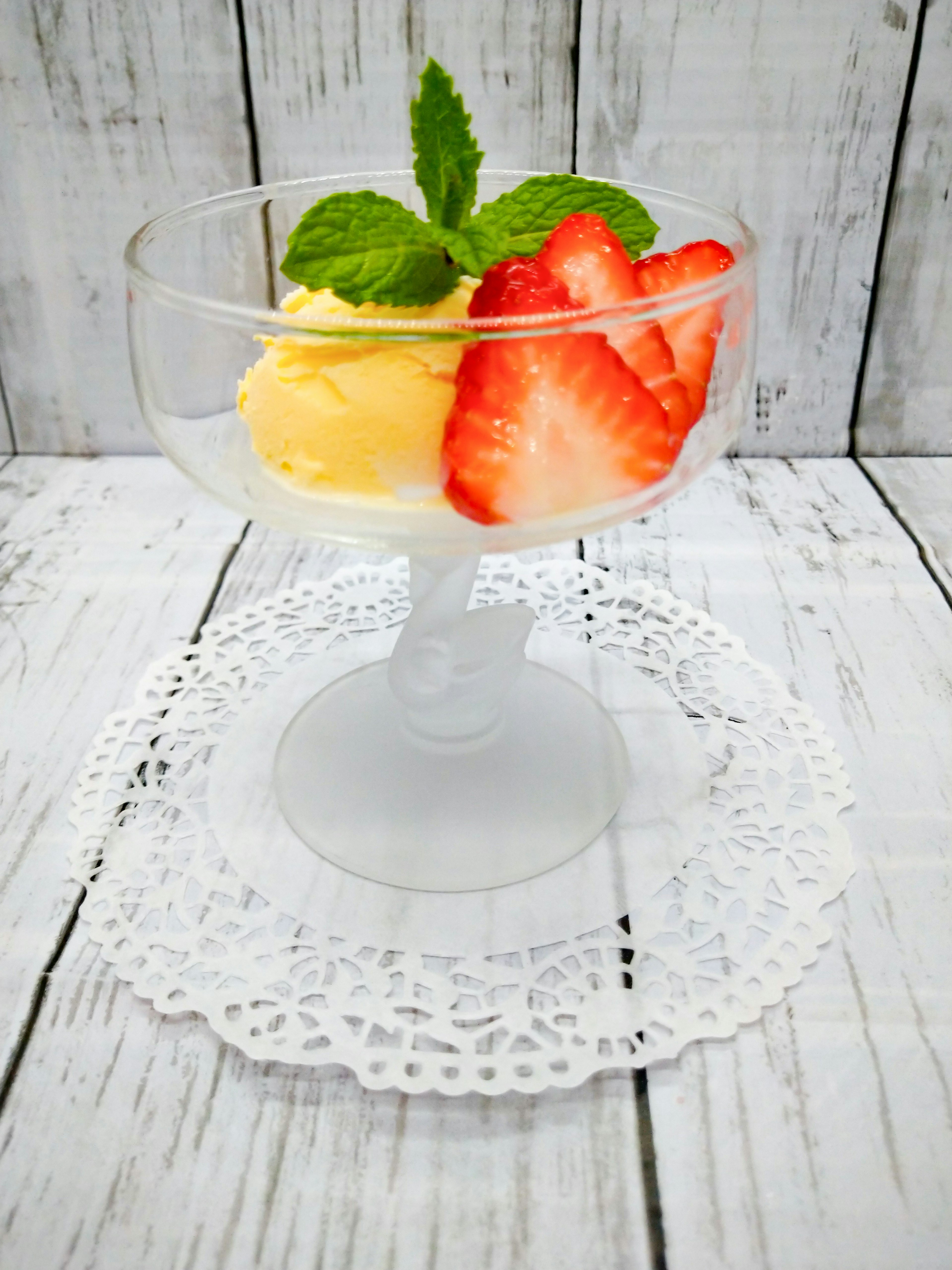 Dessert in einem klaren Glas mit Erdbeeren und Eis