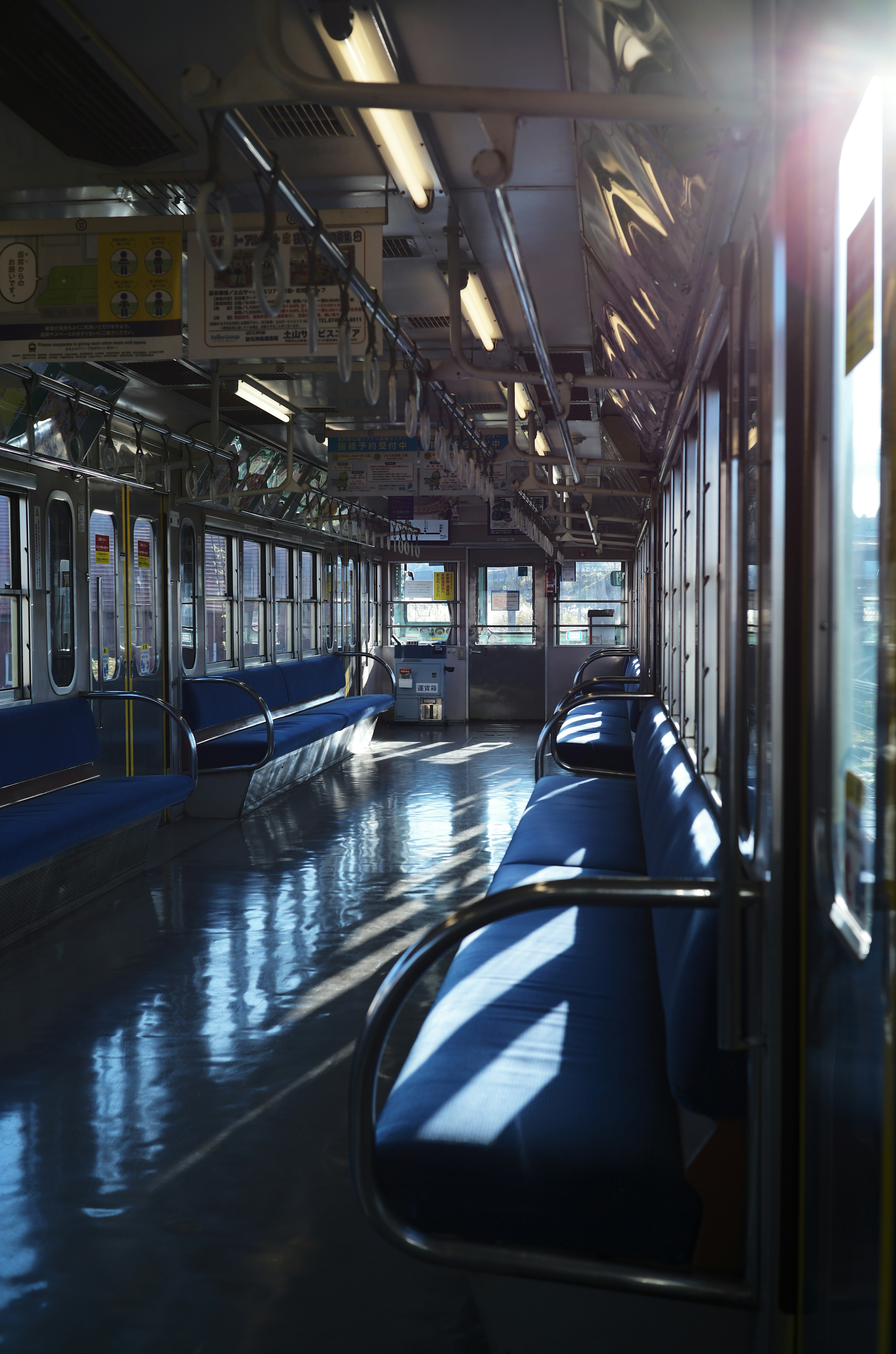 Interior of a train car with empty seats and bright natural light