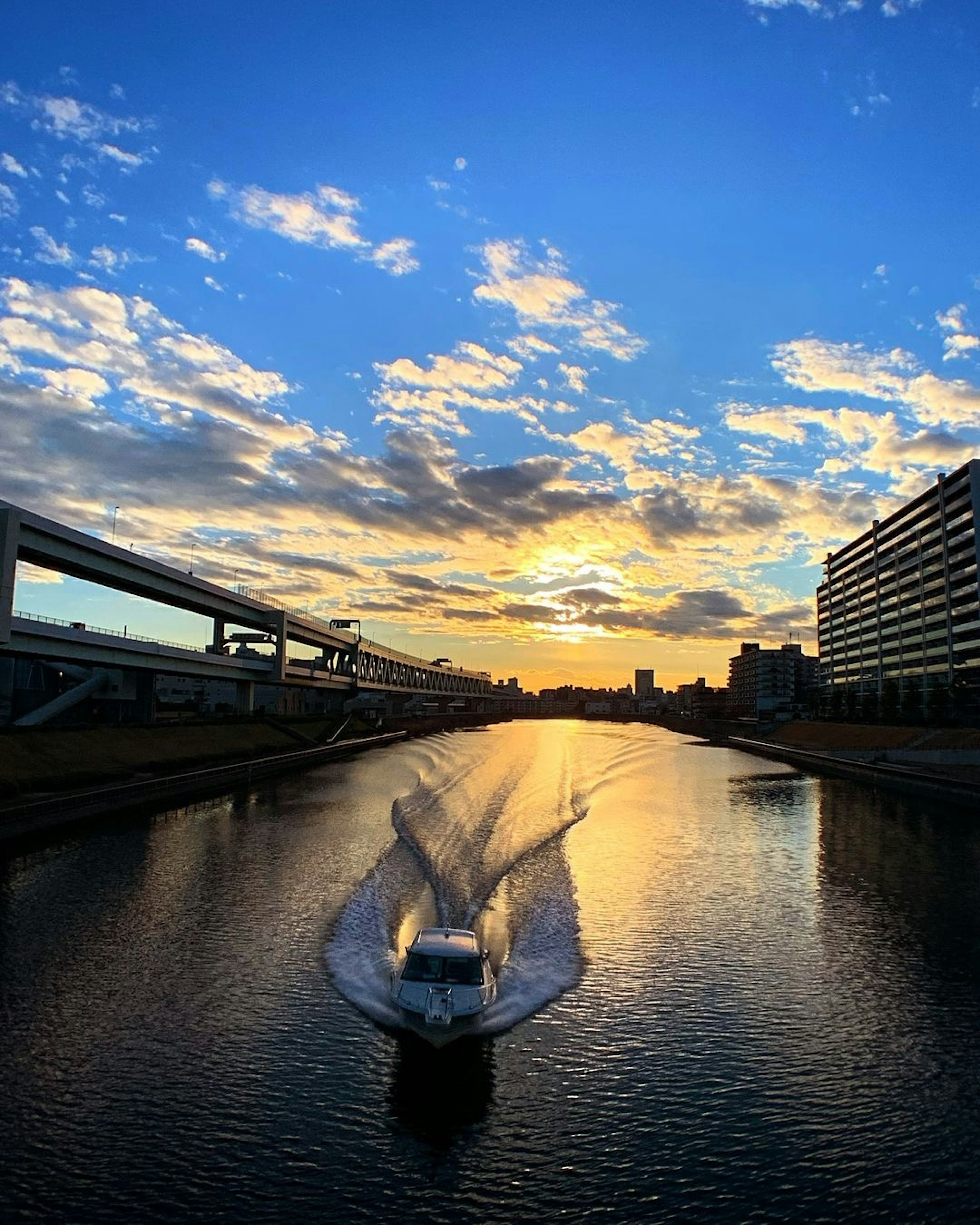 Vue pittoresque d'un bateau glissant sur l'eau sous un coucher de soleil coloré