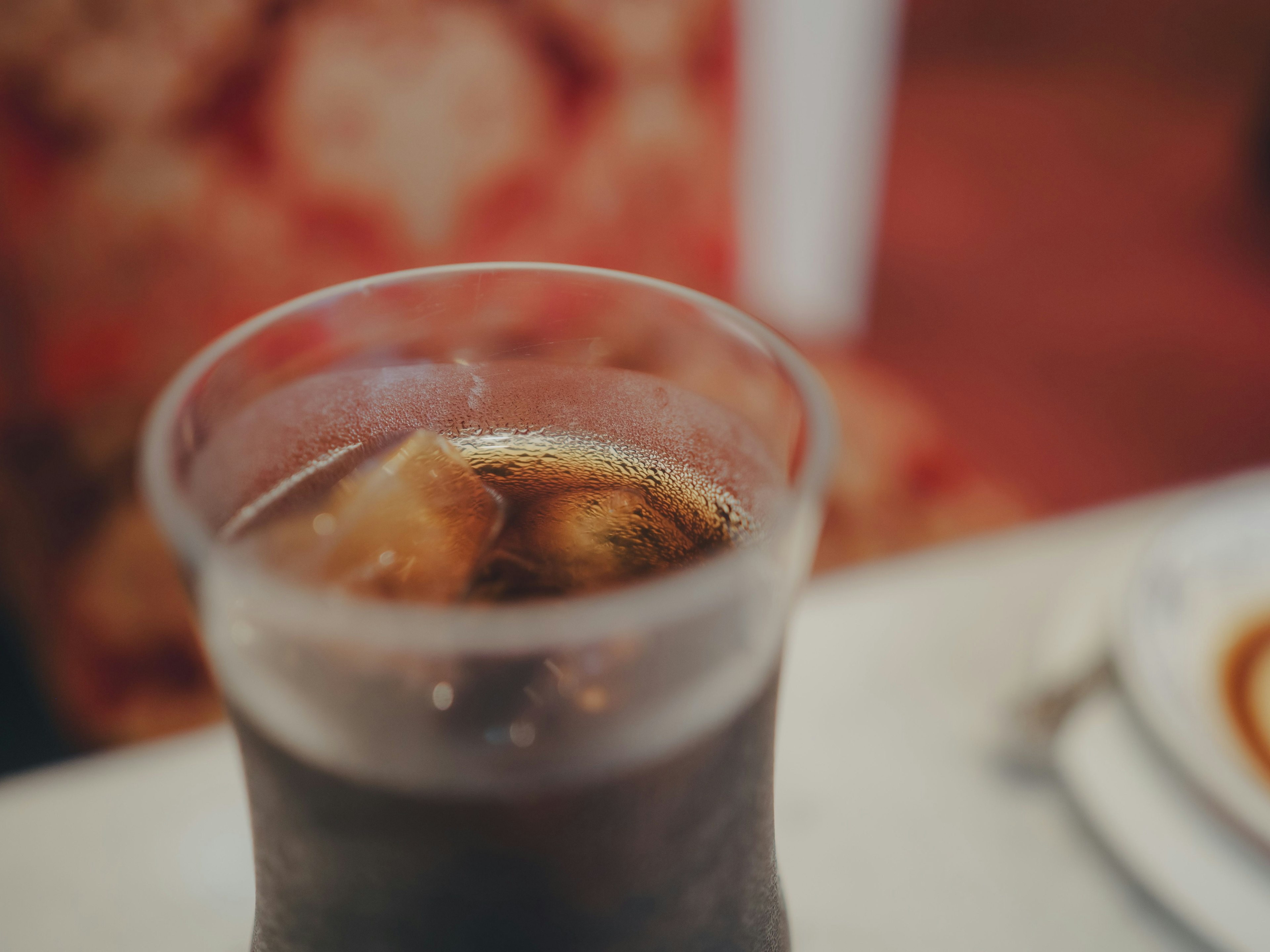 Vaso de cola con hielo y fondo decorativo