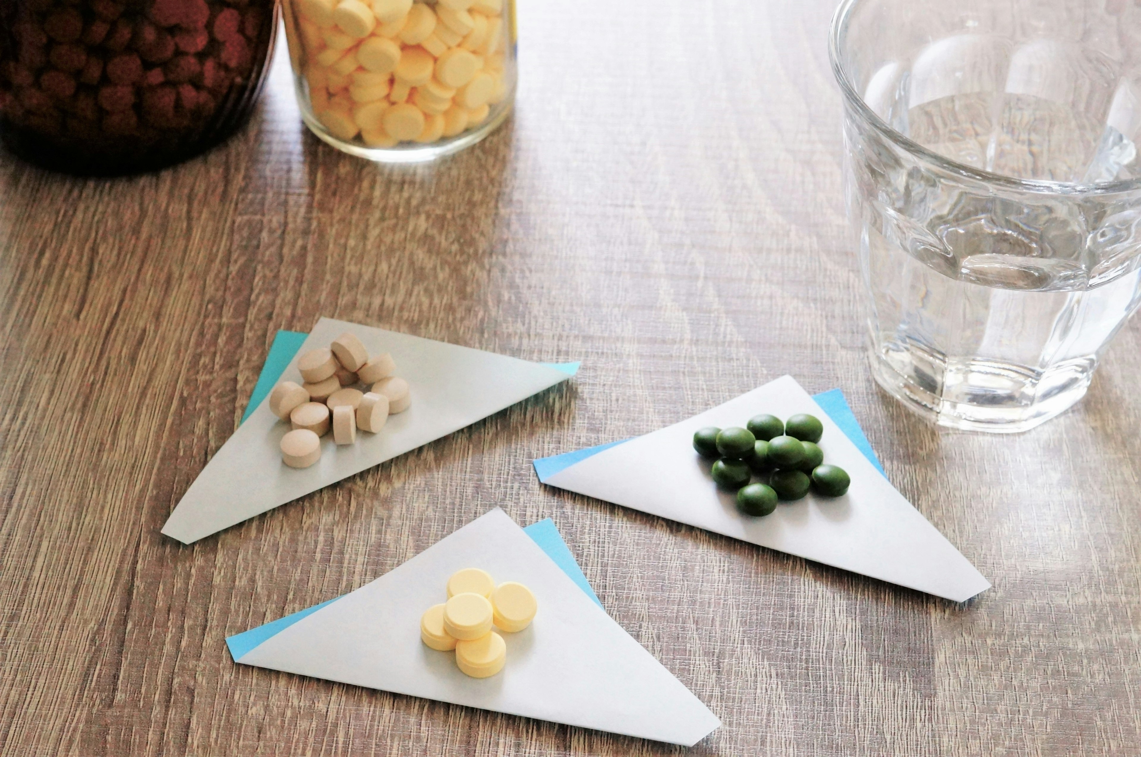 Small colored pellets arranged on triangular paper on a wooden table