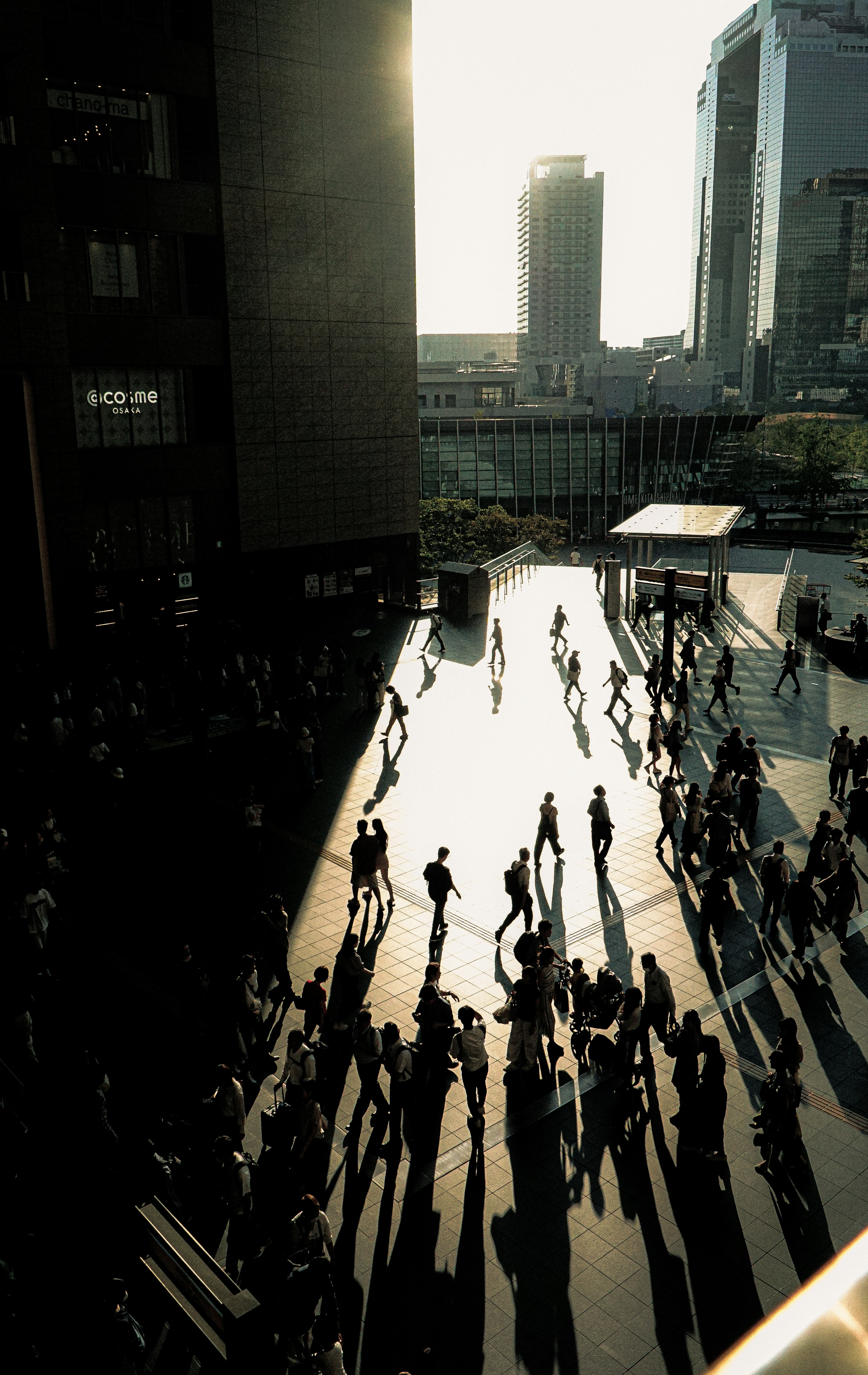 Scène urbaine avec des personnes projetant des ombres au coucher du soleil