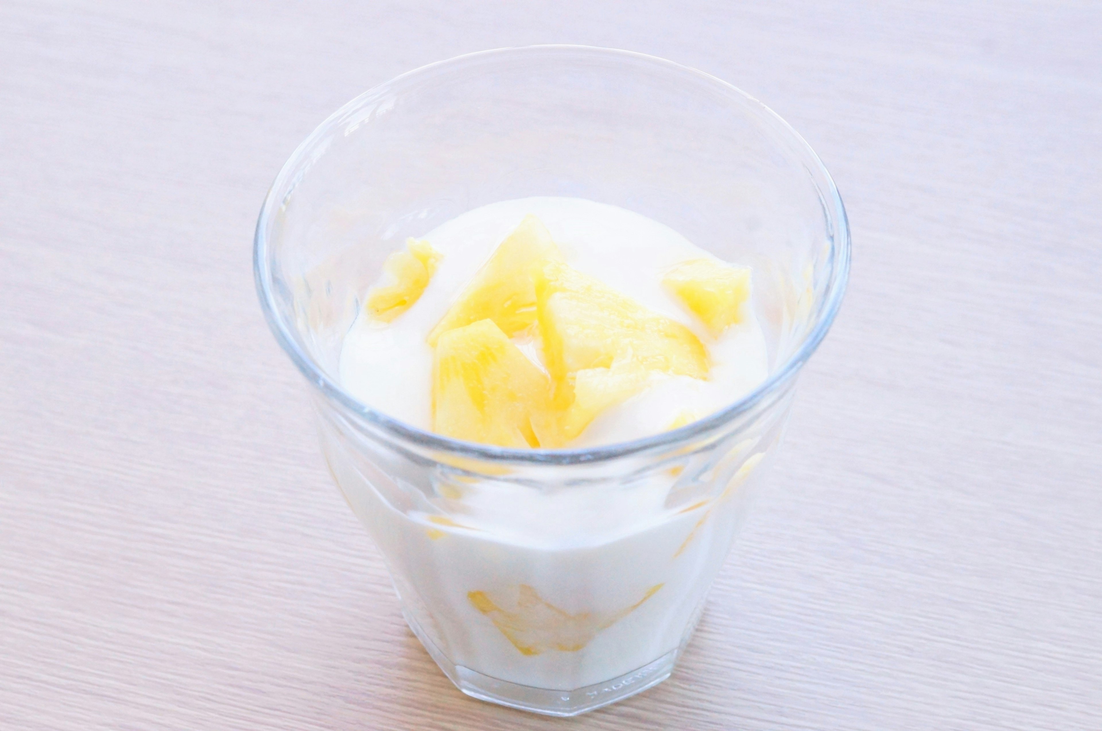 Yogurt topped with mango pieces in a clear glass