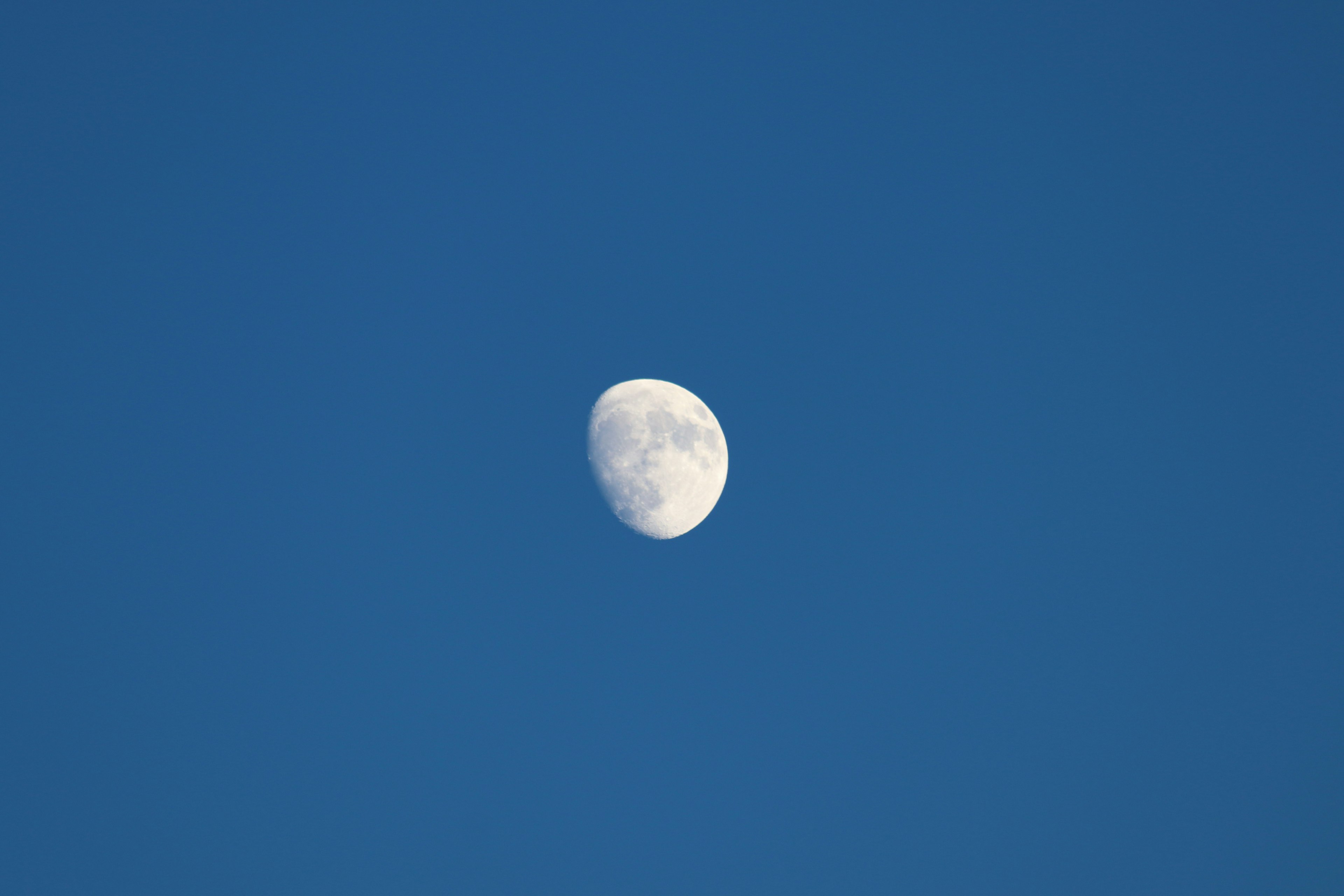 Lune gibbeuse dans un ciel bleu clair