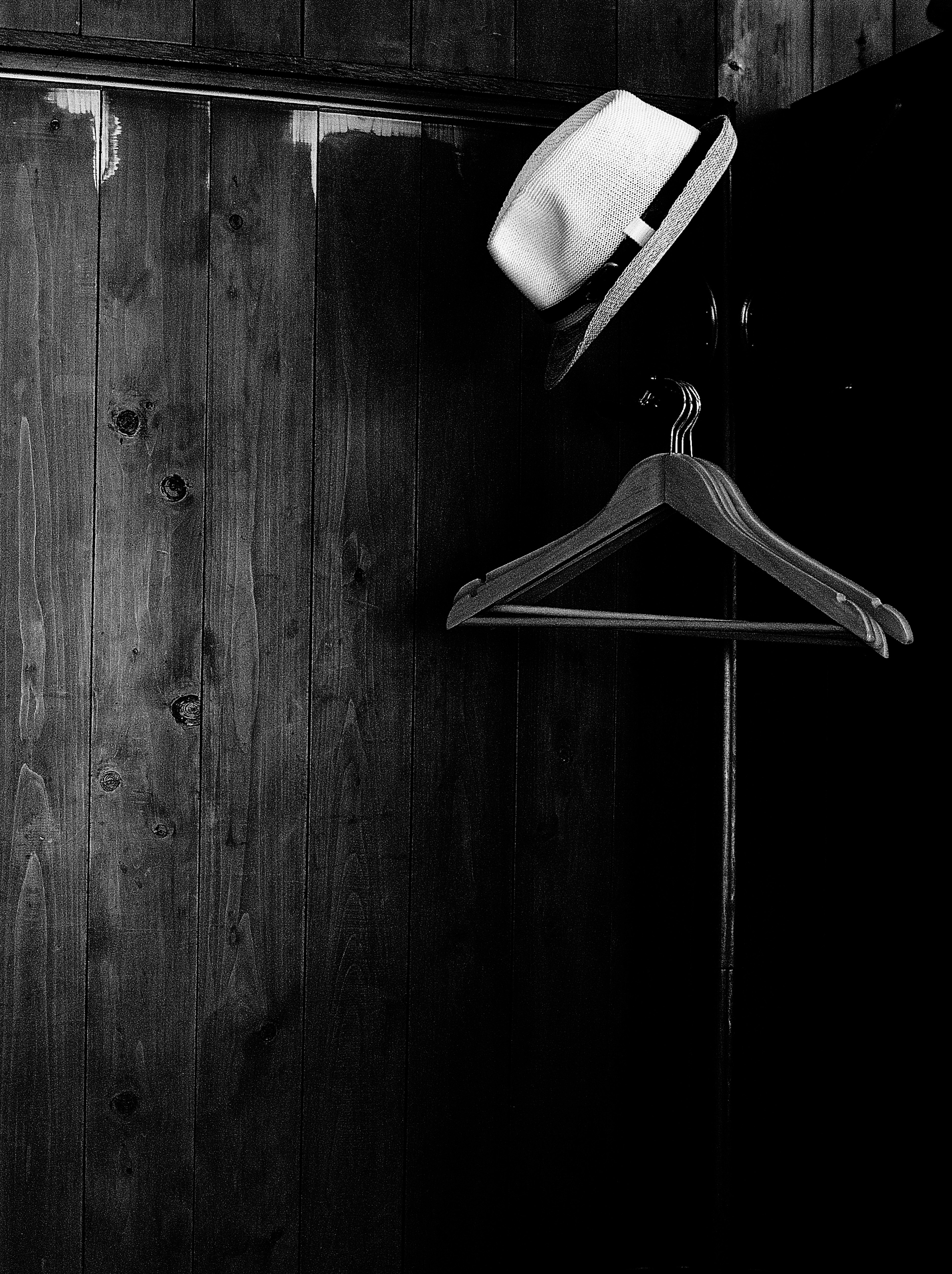 White hat hanging on a wooden closet wall