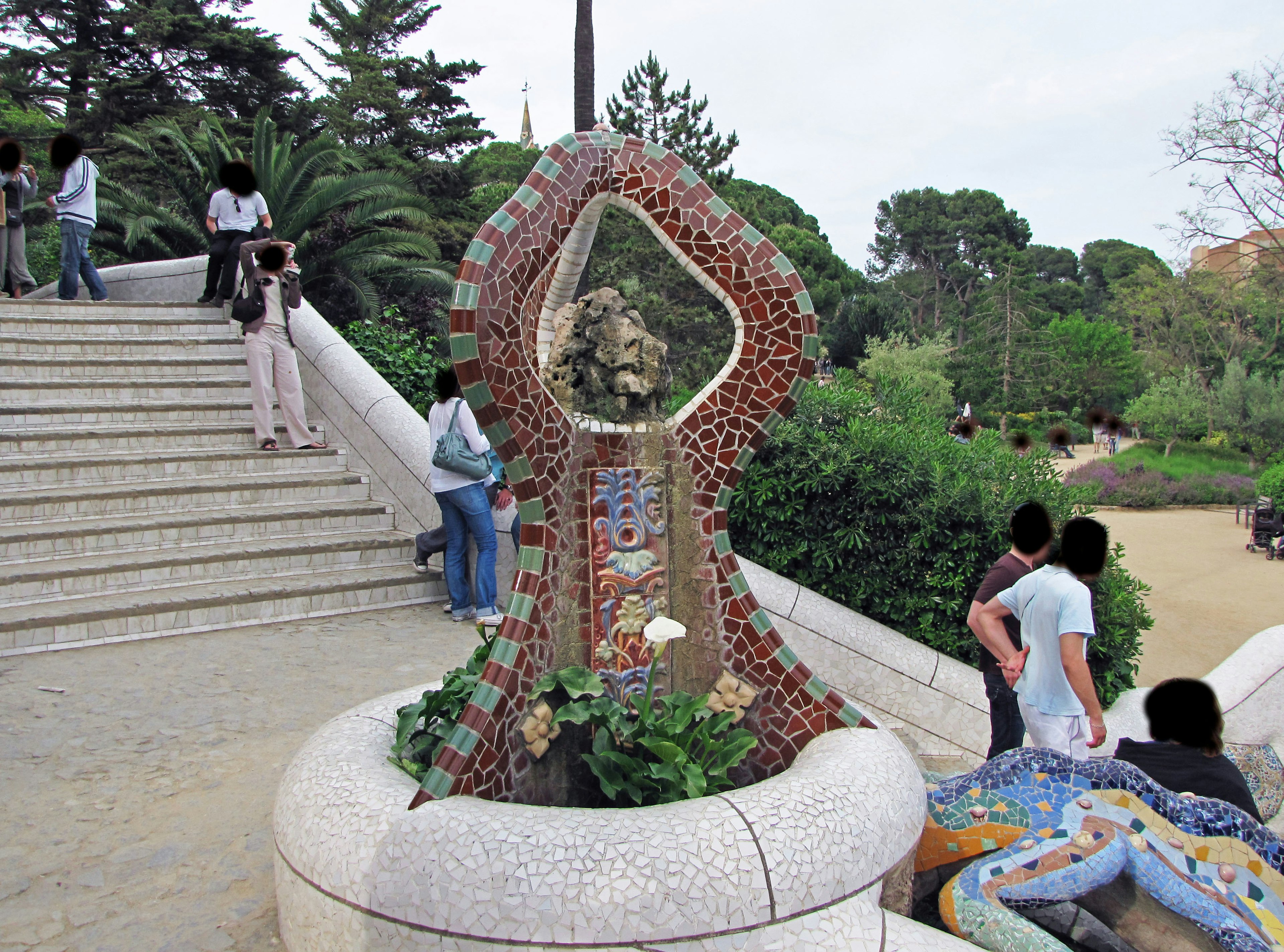 Mosaic sculpture in a park with people on the stairs