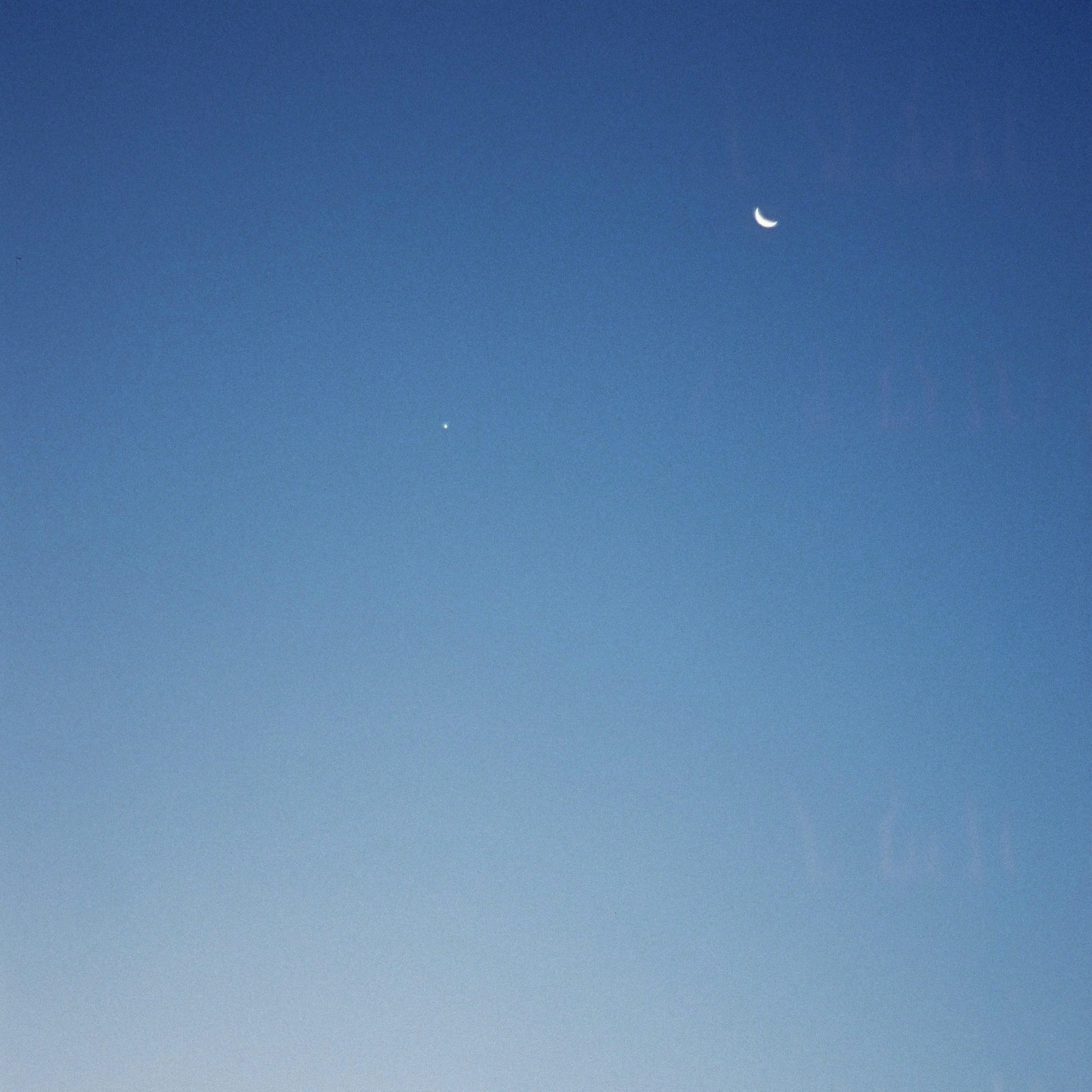 青空に浮かぶ月と星のシンプルな風景