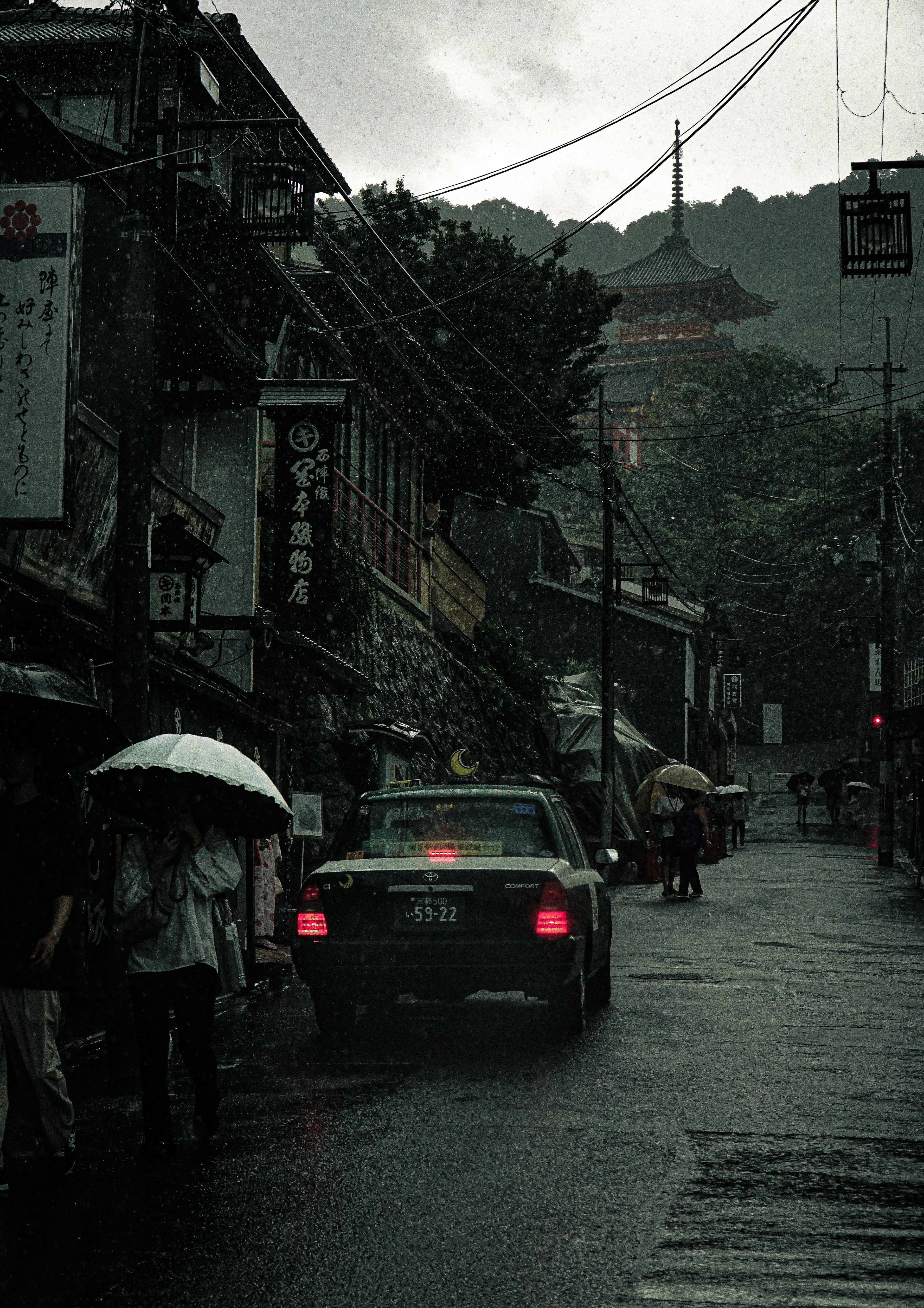 Scène de rue sous la pluie avec un taxi et des piétons