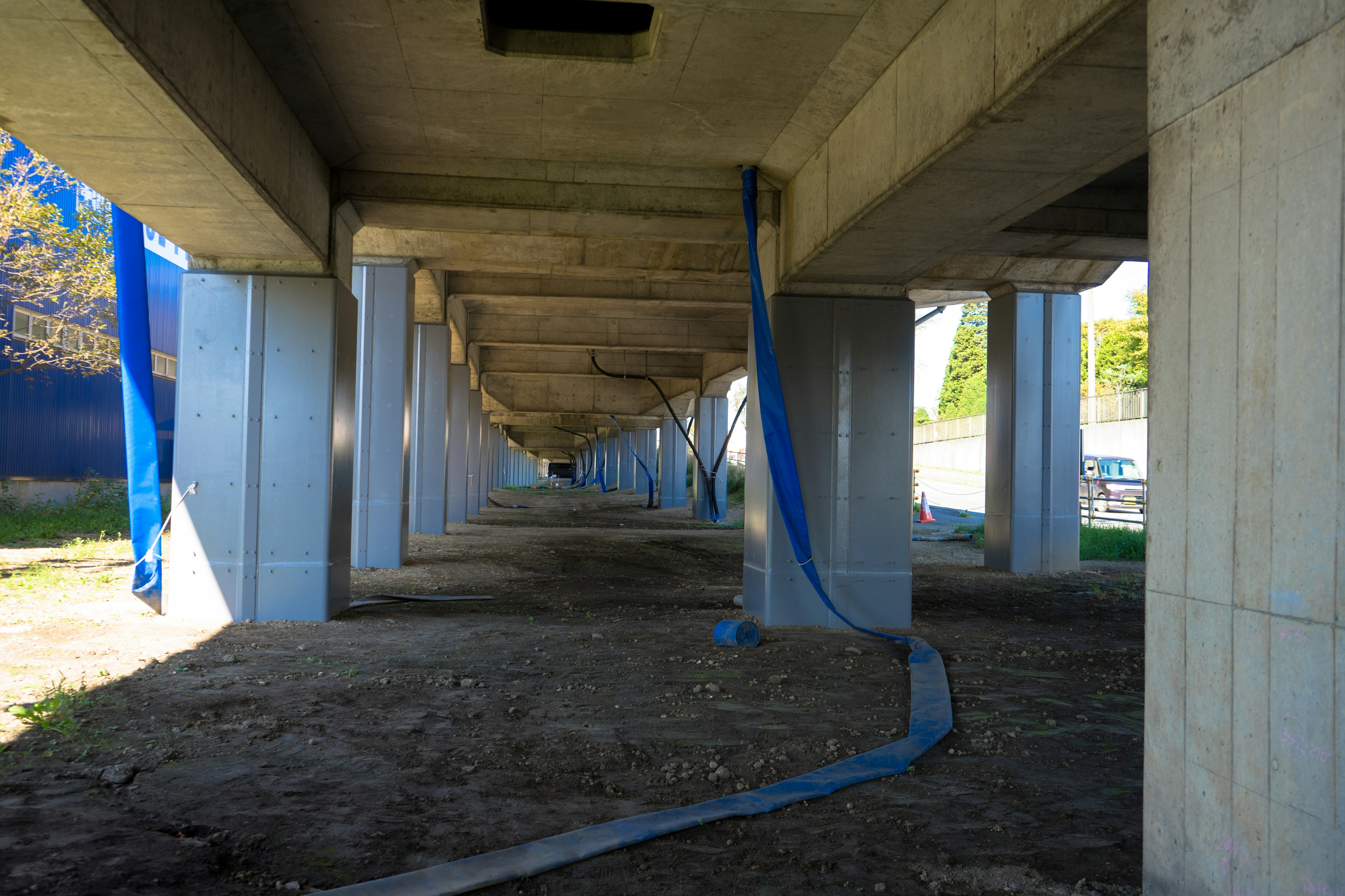 Vista del lado inferior de un puente de concreto con tela azul colgando