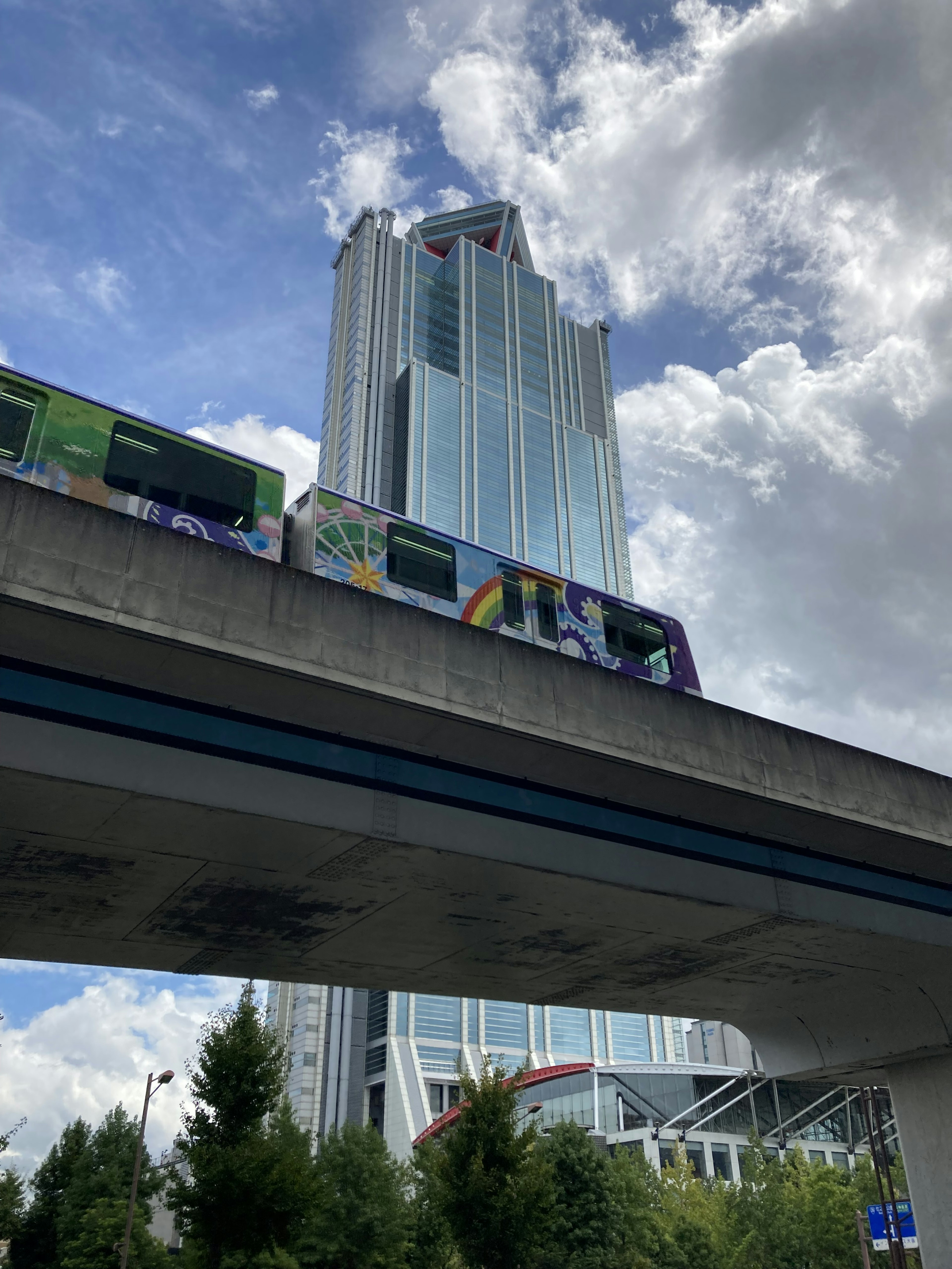 Ein hoher Bau mit einer Monorail, die unter einem blauen Himmel hindurchfährt