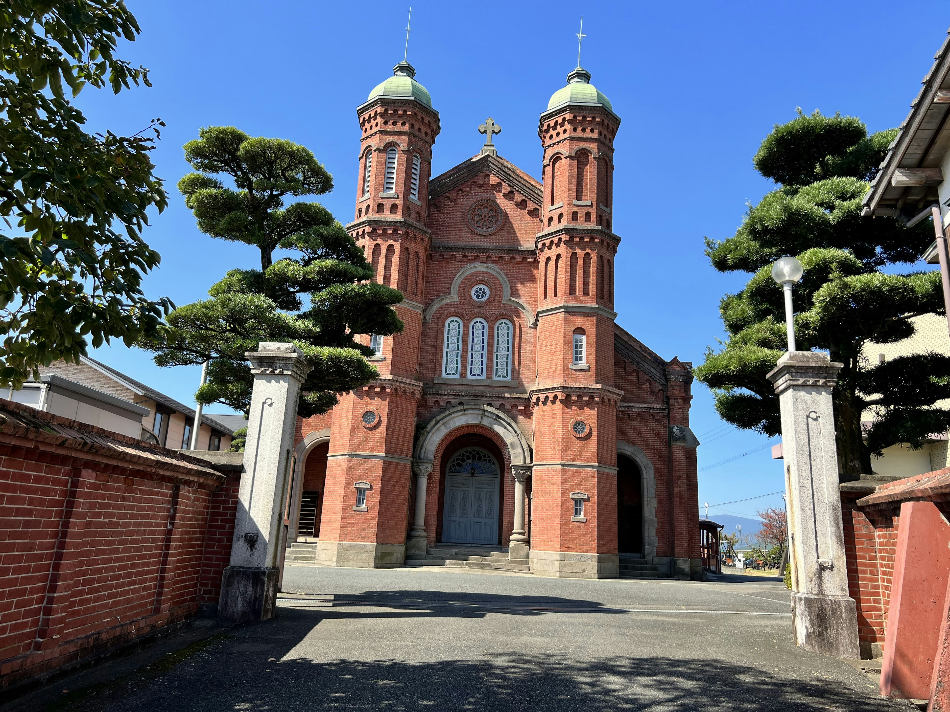 Außenansicht einer roten Backsteinkirche mit blauem Himmel im Hintergrund