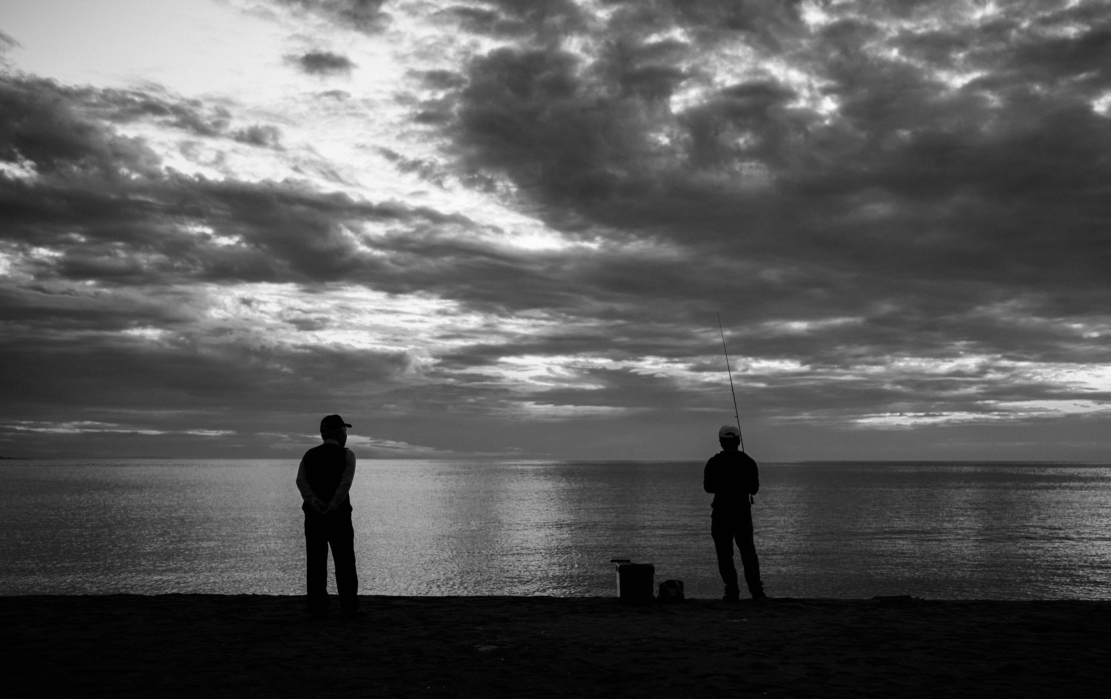 海辺での二人のシルエットと雲のある空