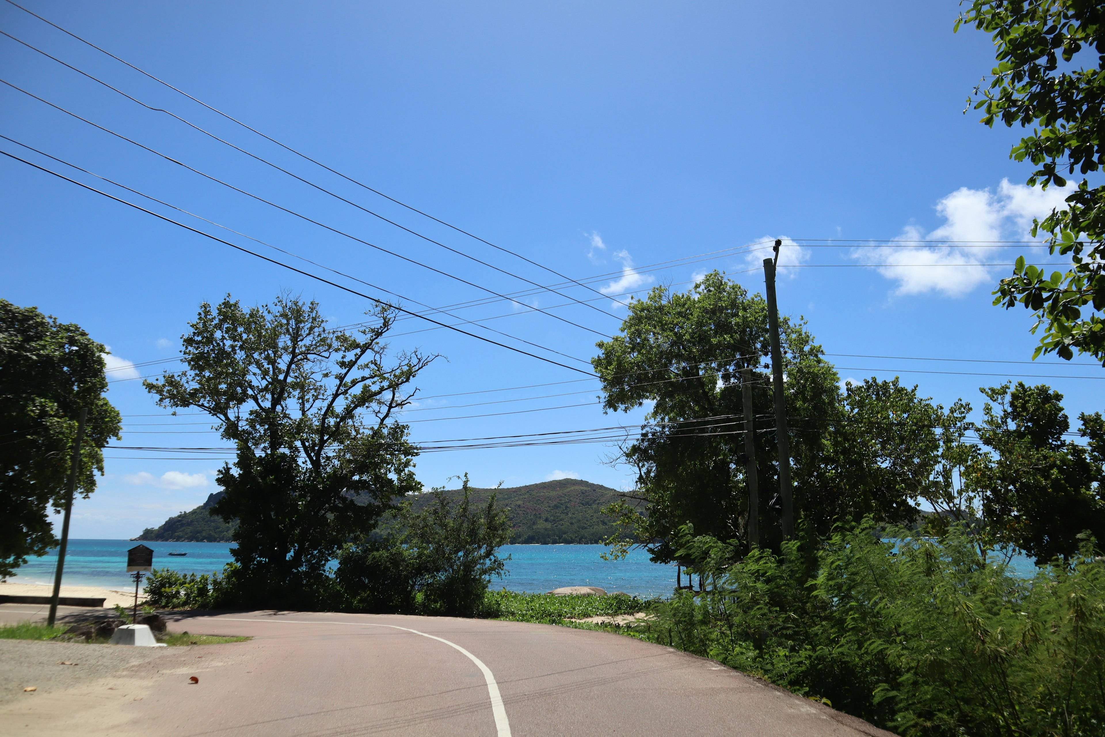 Kurvenstraße mit Blick auf das blaue Meer und den Himmel