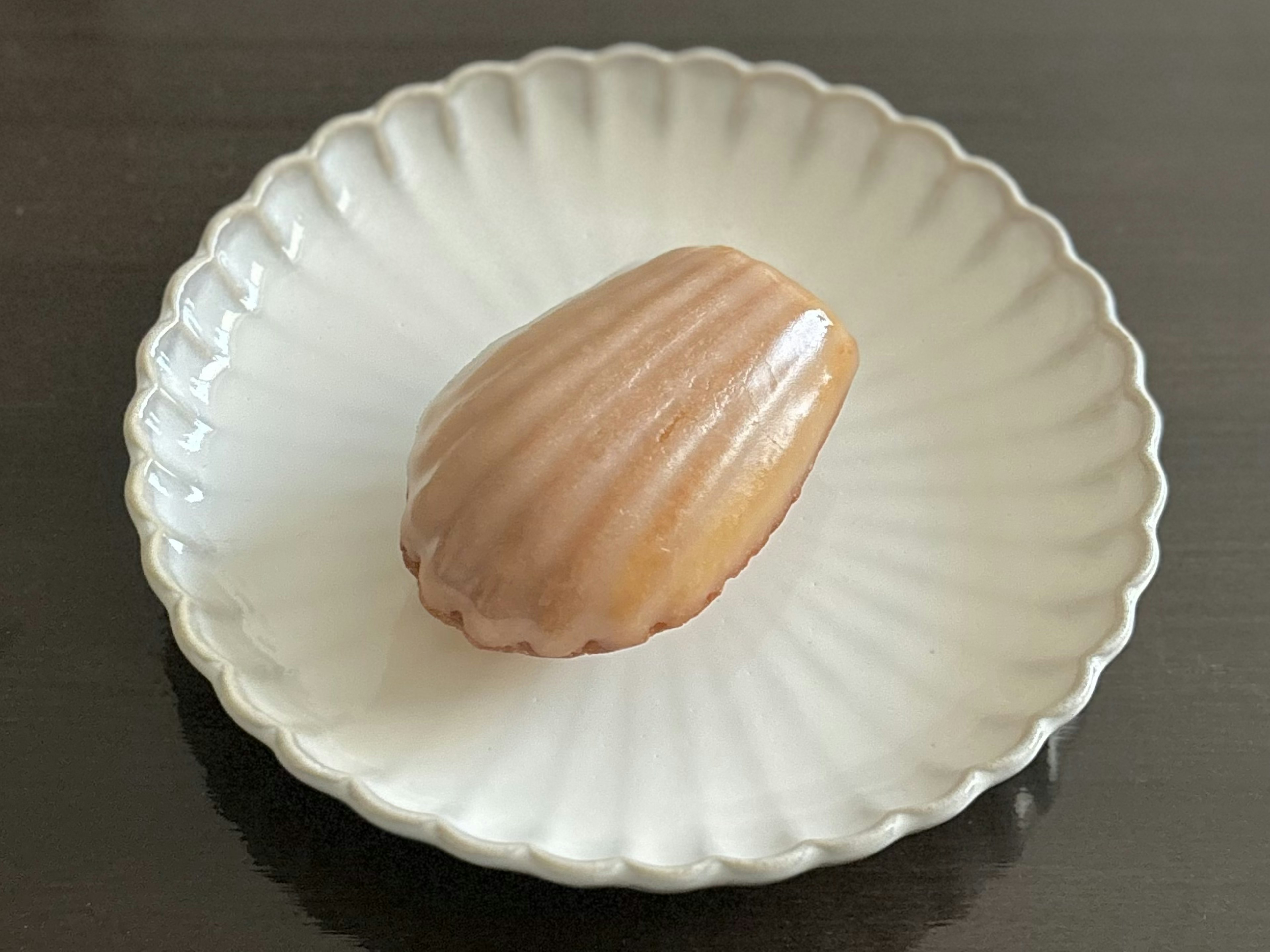 白い皿の上に置かれた焼き菓子のマドレーヌ