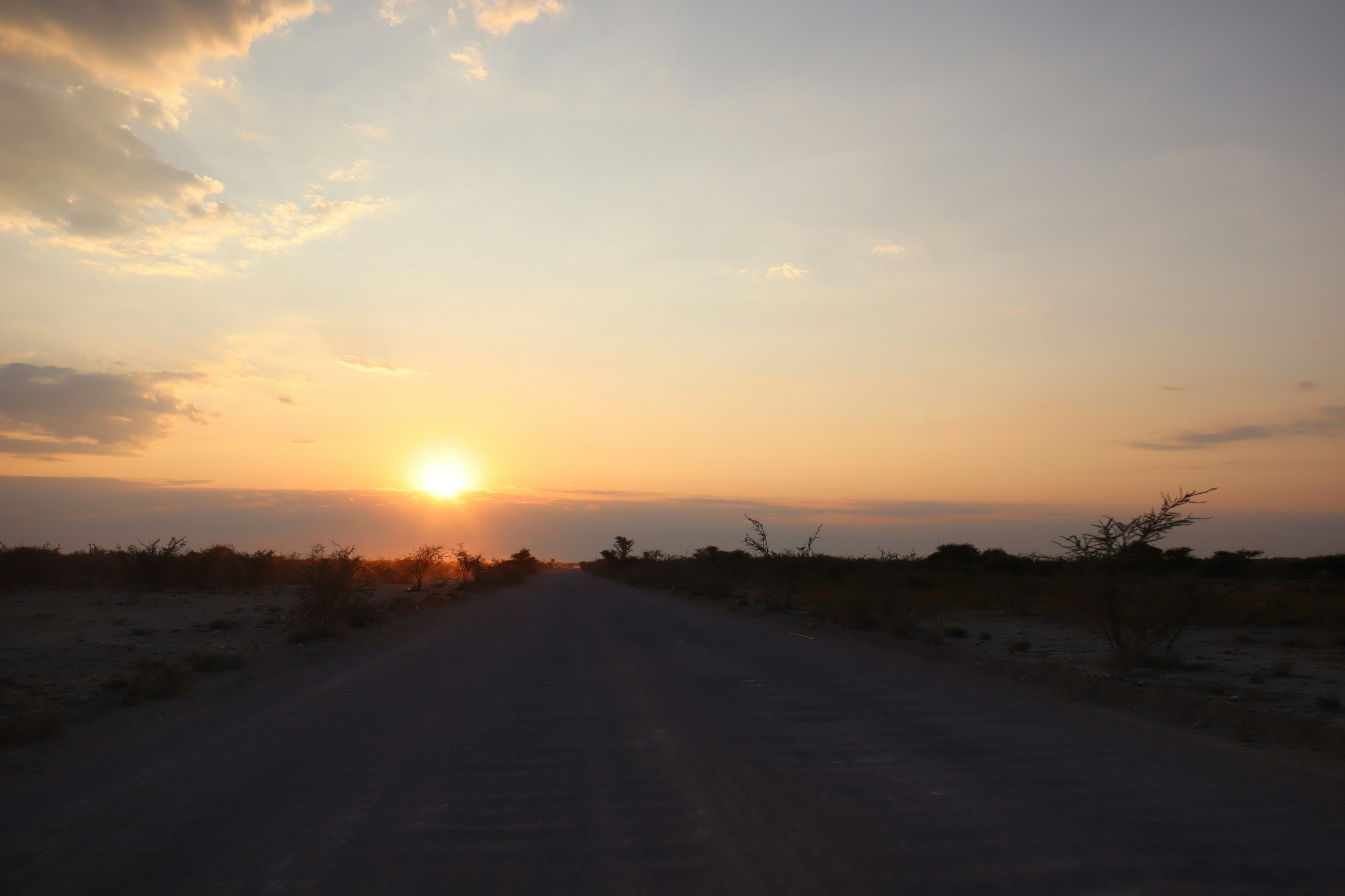 Una strada con un tramonto sullo sfondo