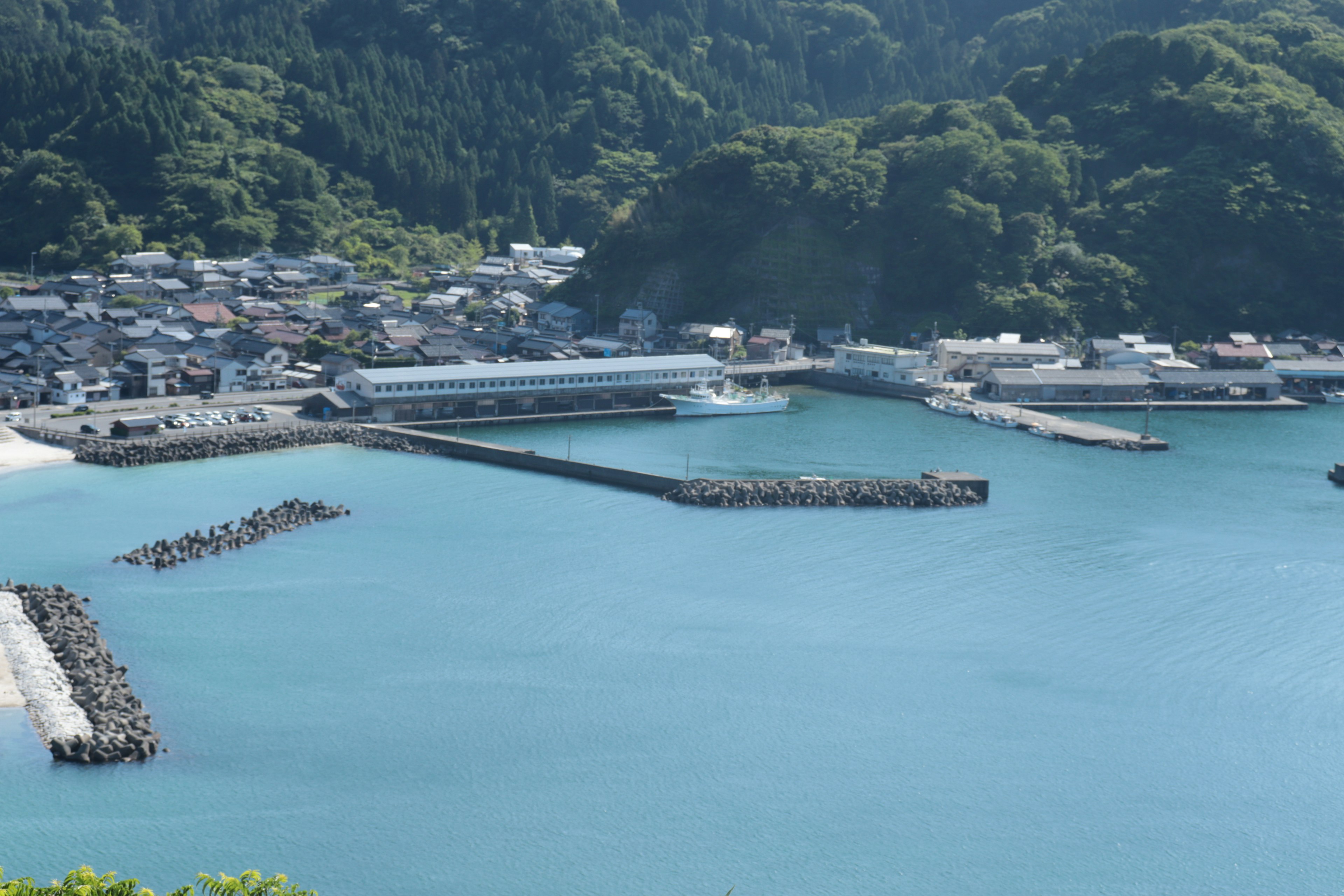 藍色海洋和港口的風景，周圍有山和房屋