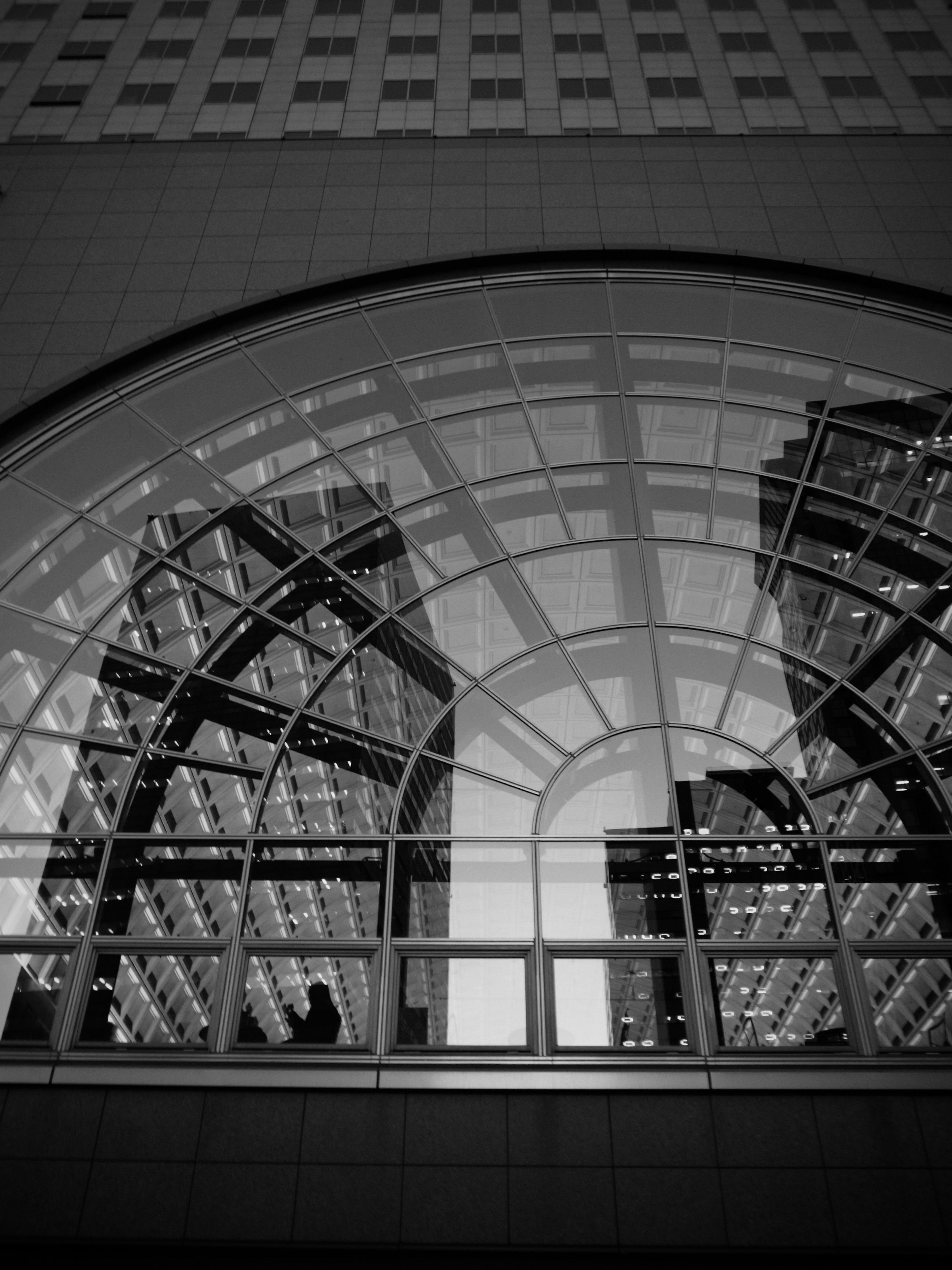 Reflection of buildings through an arched glass window