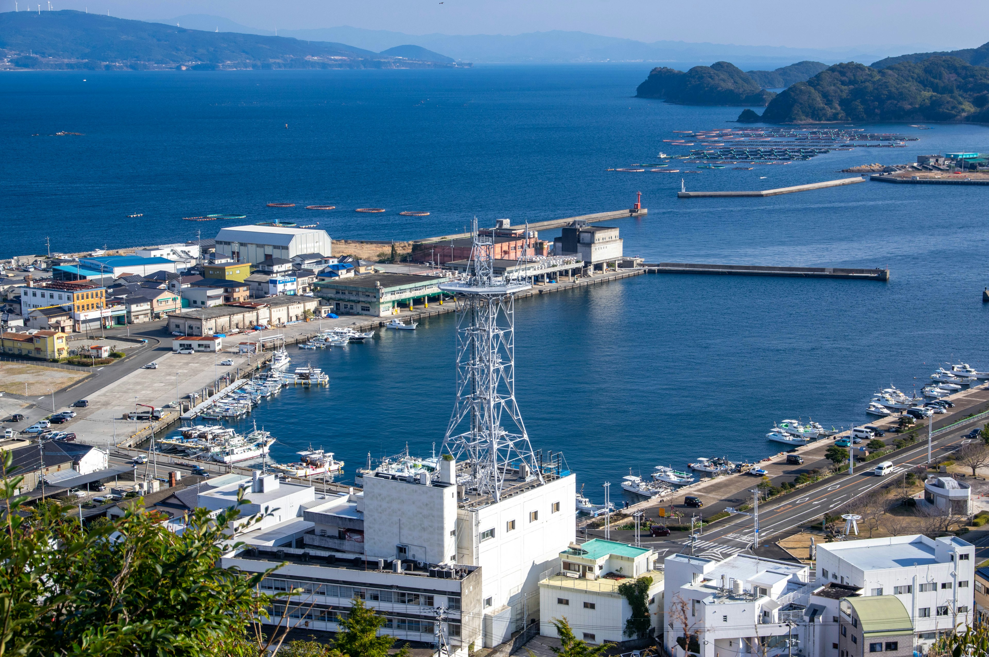 Aerial view of a harbor with boats and commercial buildings along the coastline