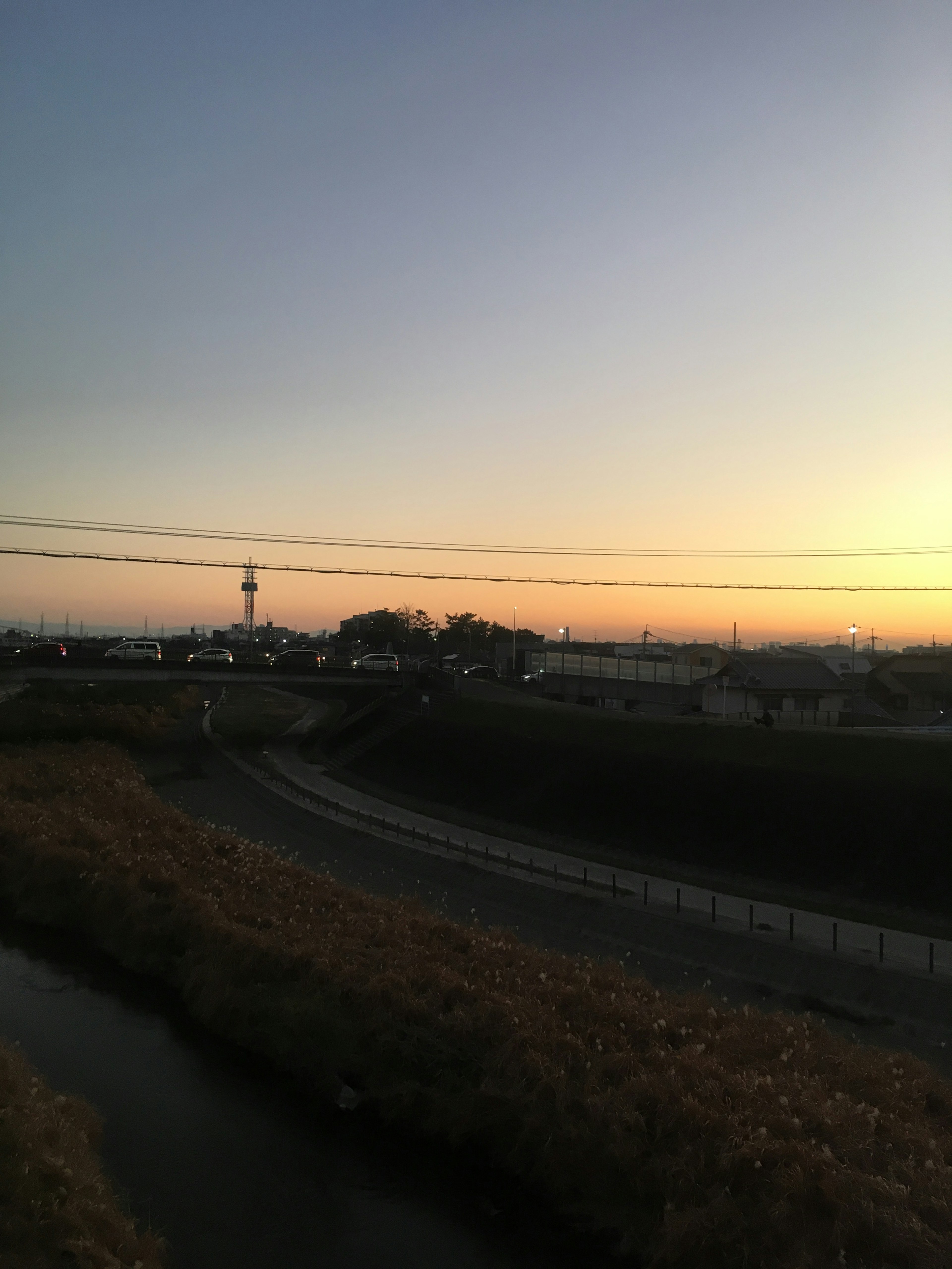 Vue pittoresque d'une rivière au crépuscule avec des lignes téléphoniques