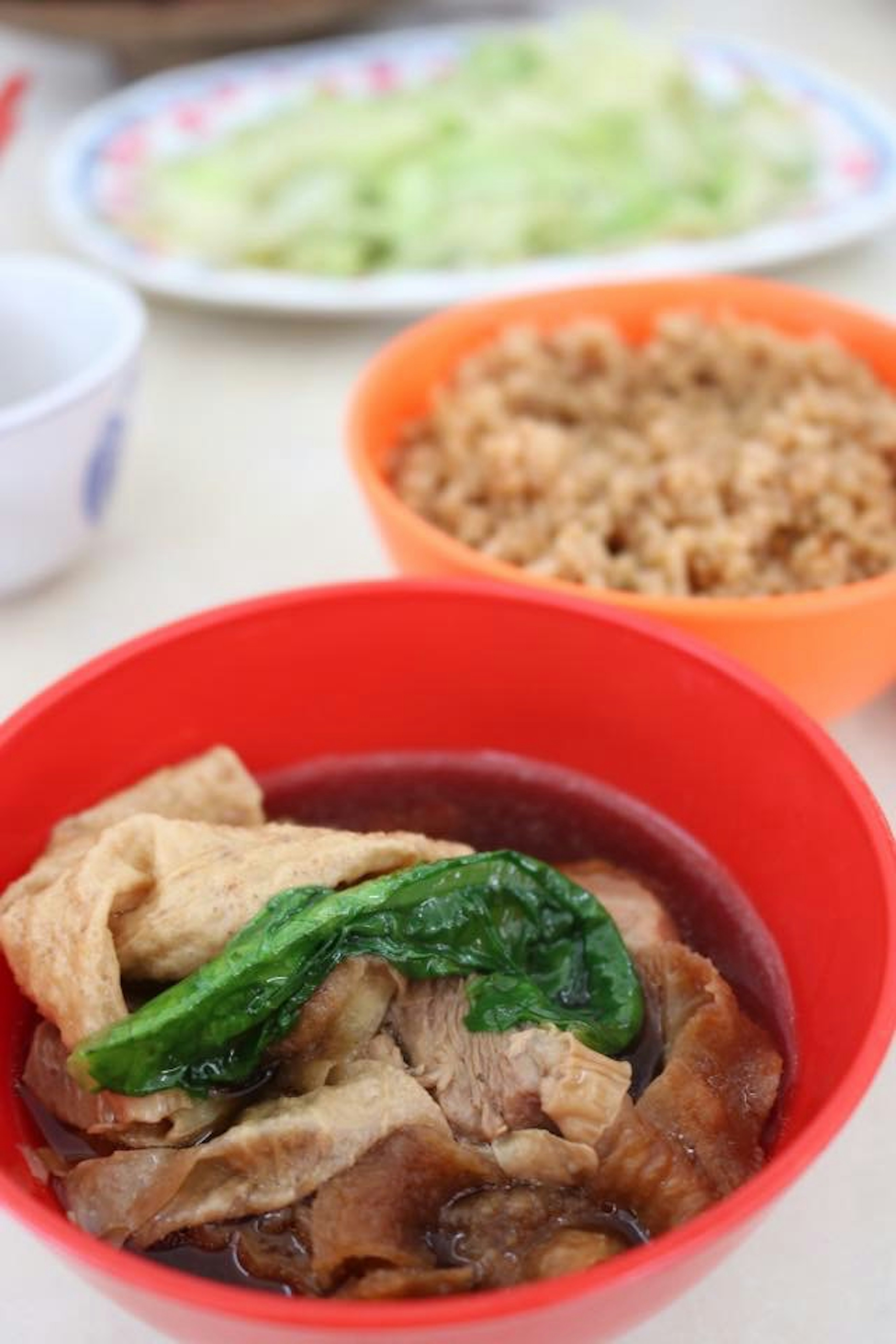 Braised chicken with spinach in a red bowl