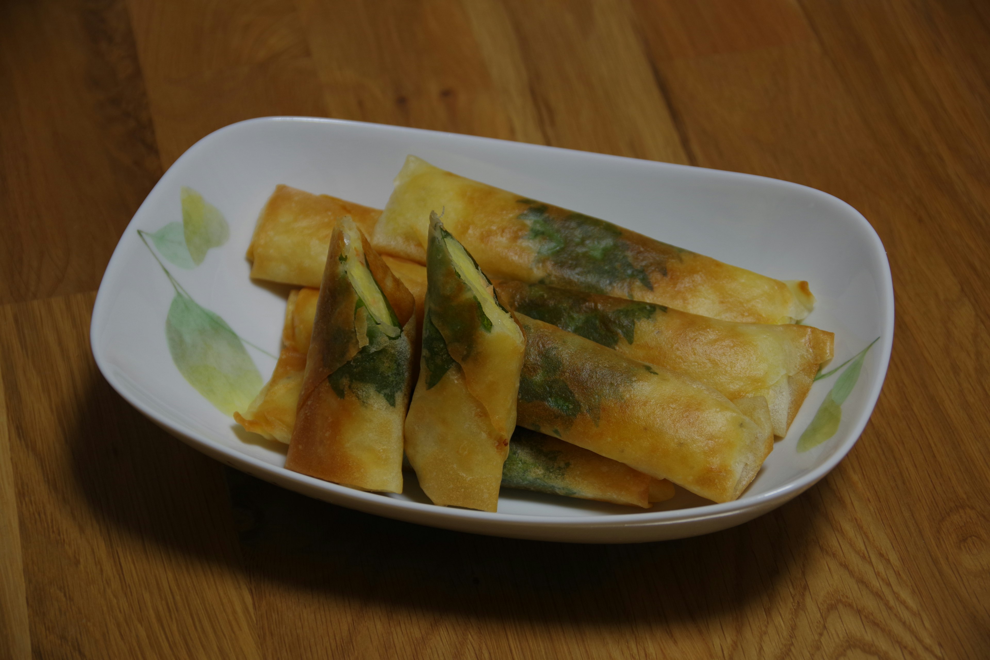 Rouleaux de printemps frits disposés sur une assiette blanche