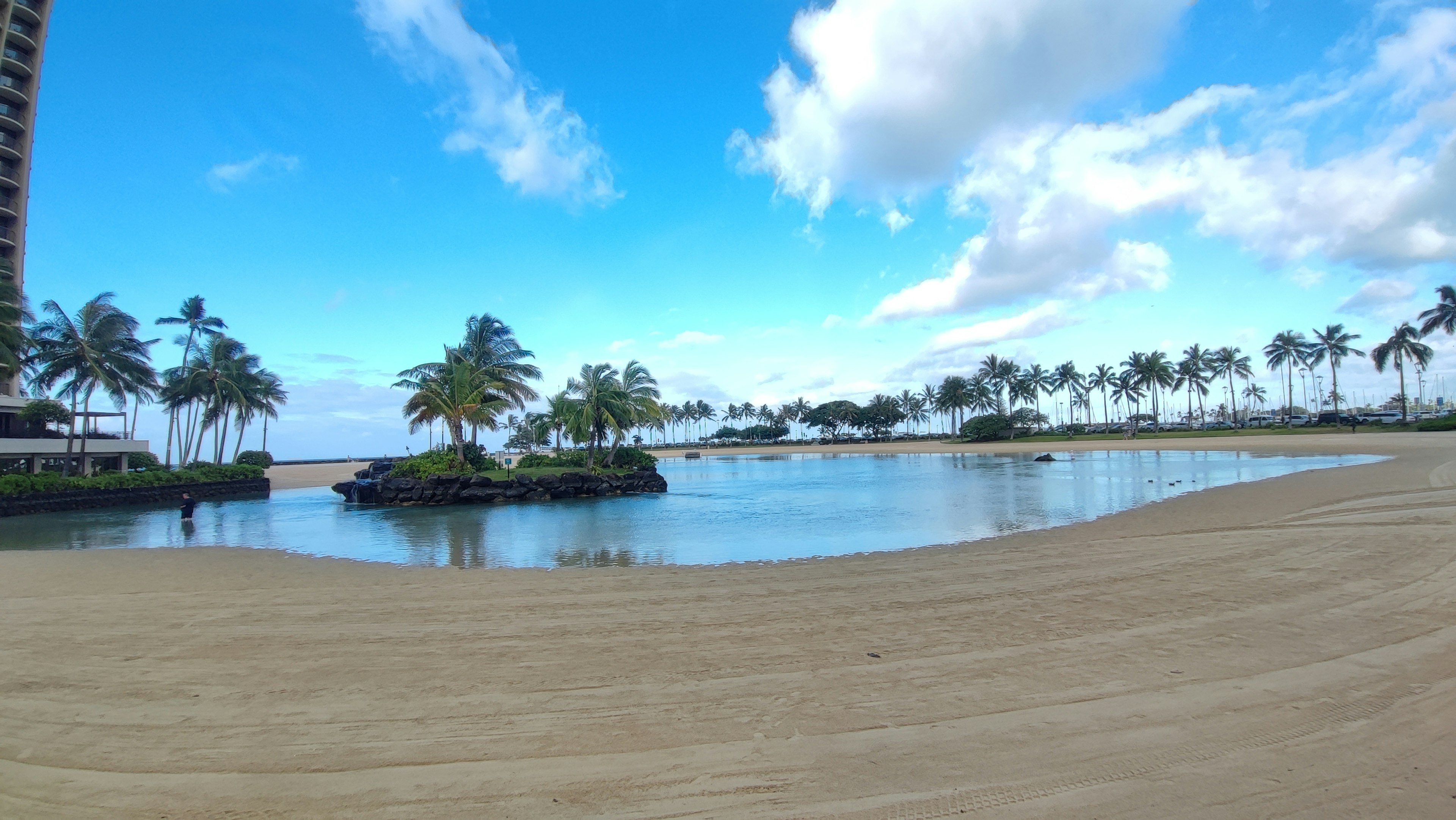 Vue de plage pittoresque avec ciel bleu et nuages blancs eau calme et palmiers