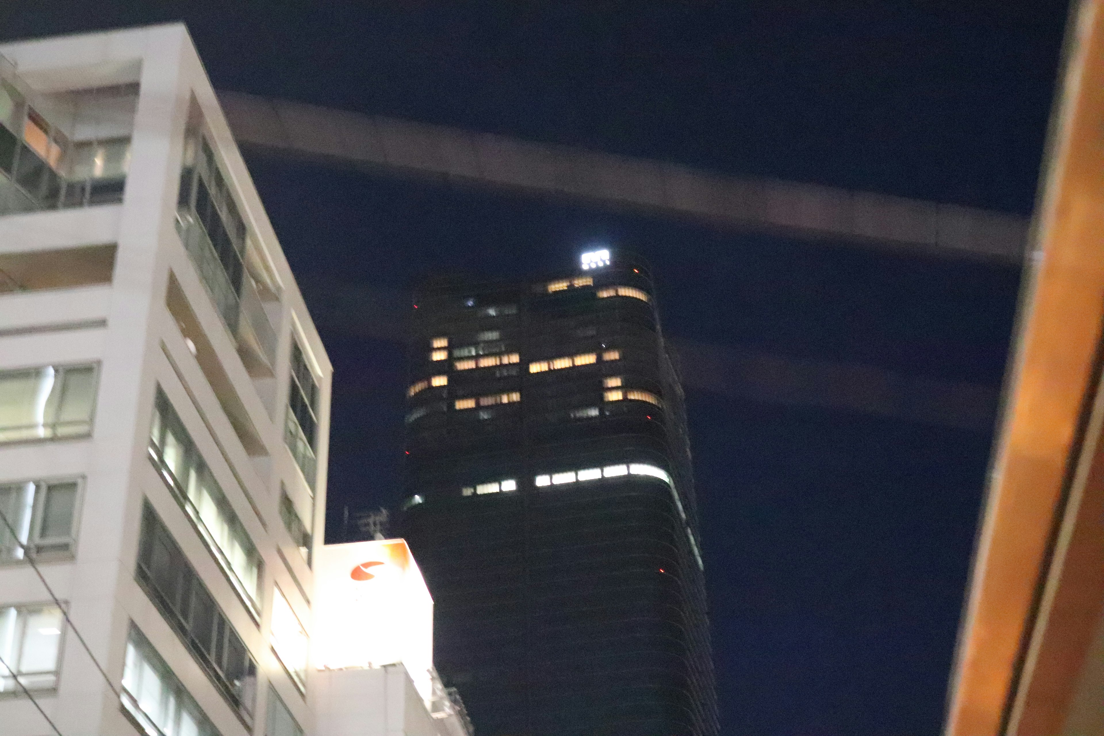 Silhouette of skyscraper and surrounding buildings at night