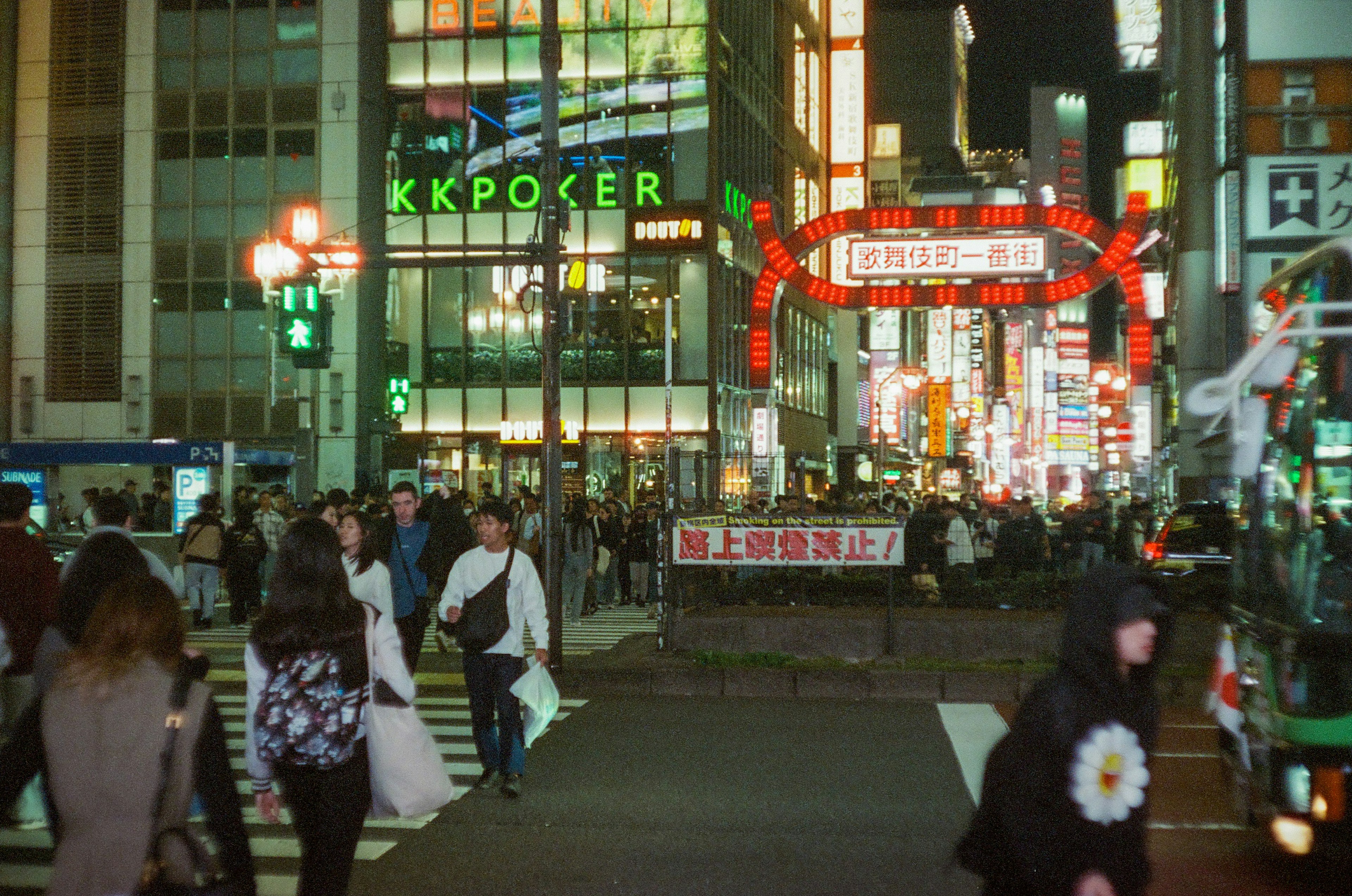 夜の街並みに人々が歩いている様子と明るい看板