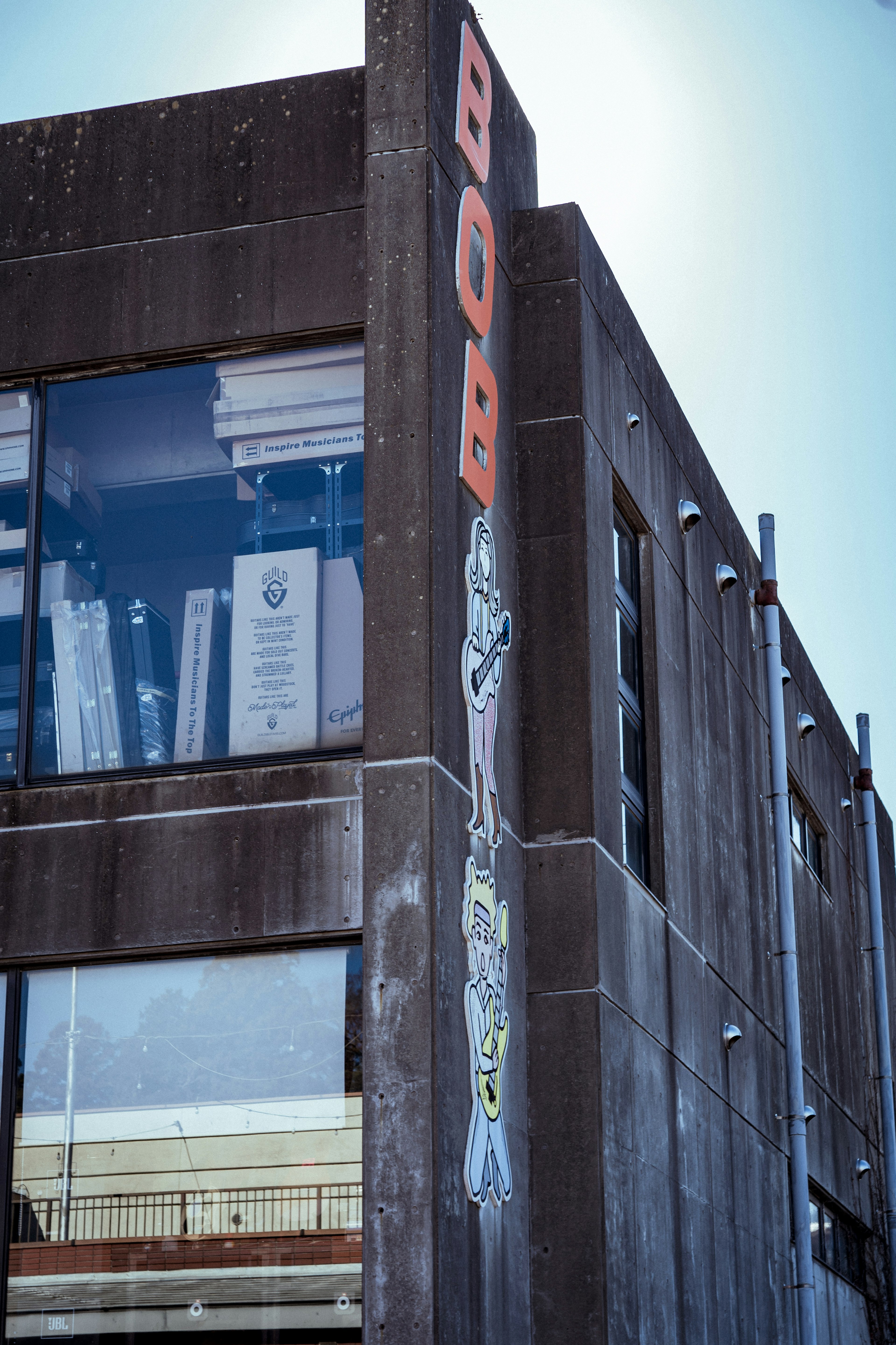 Image of a concrete building with a prominent red sign and visible windows