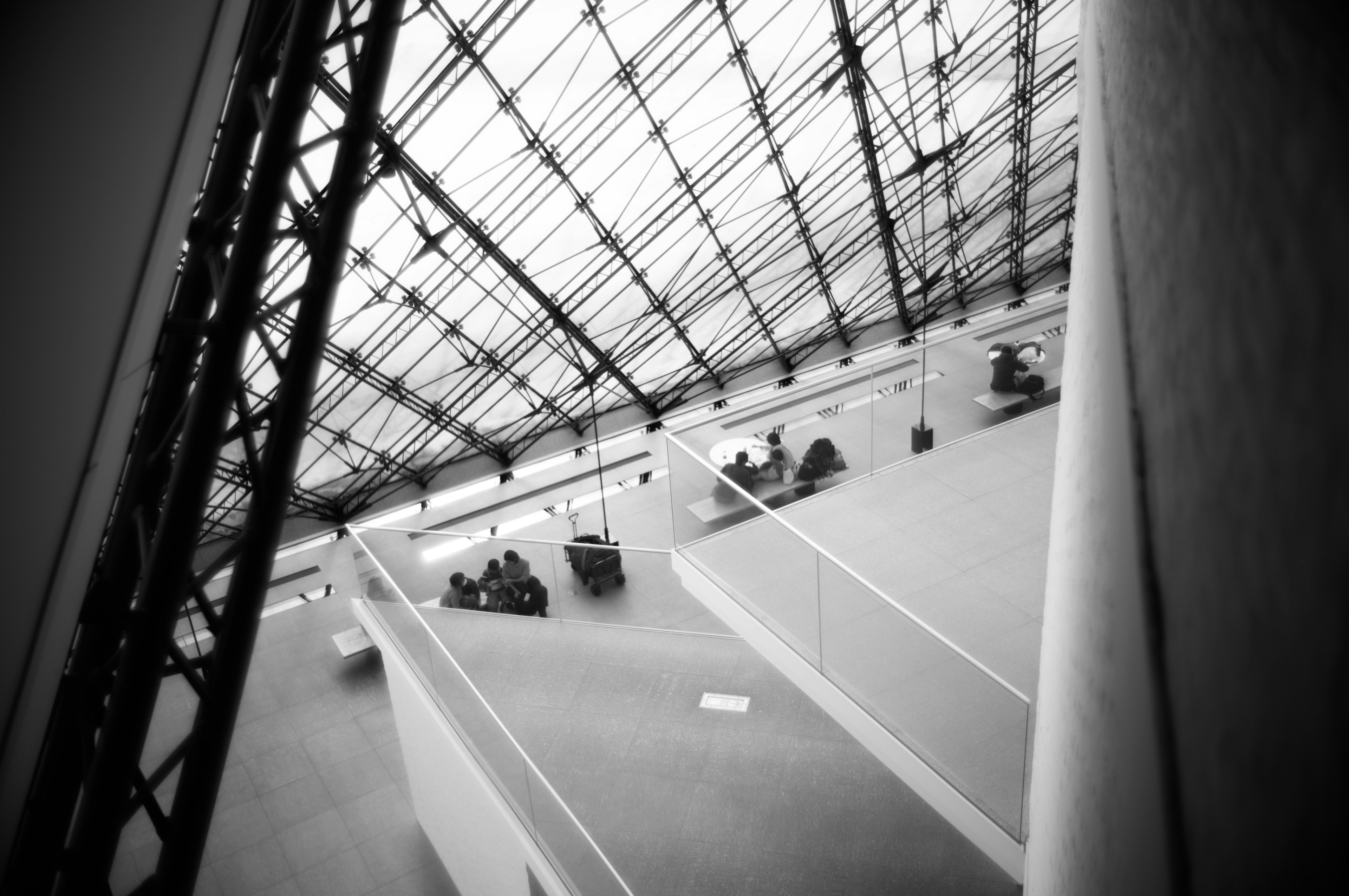 Interior of a modern building with a glass ceiling featuring people