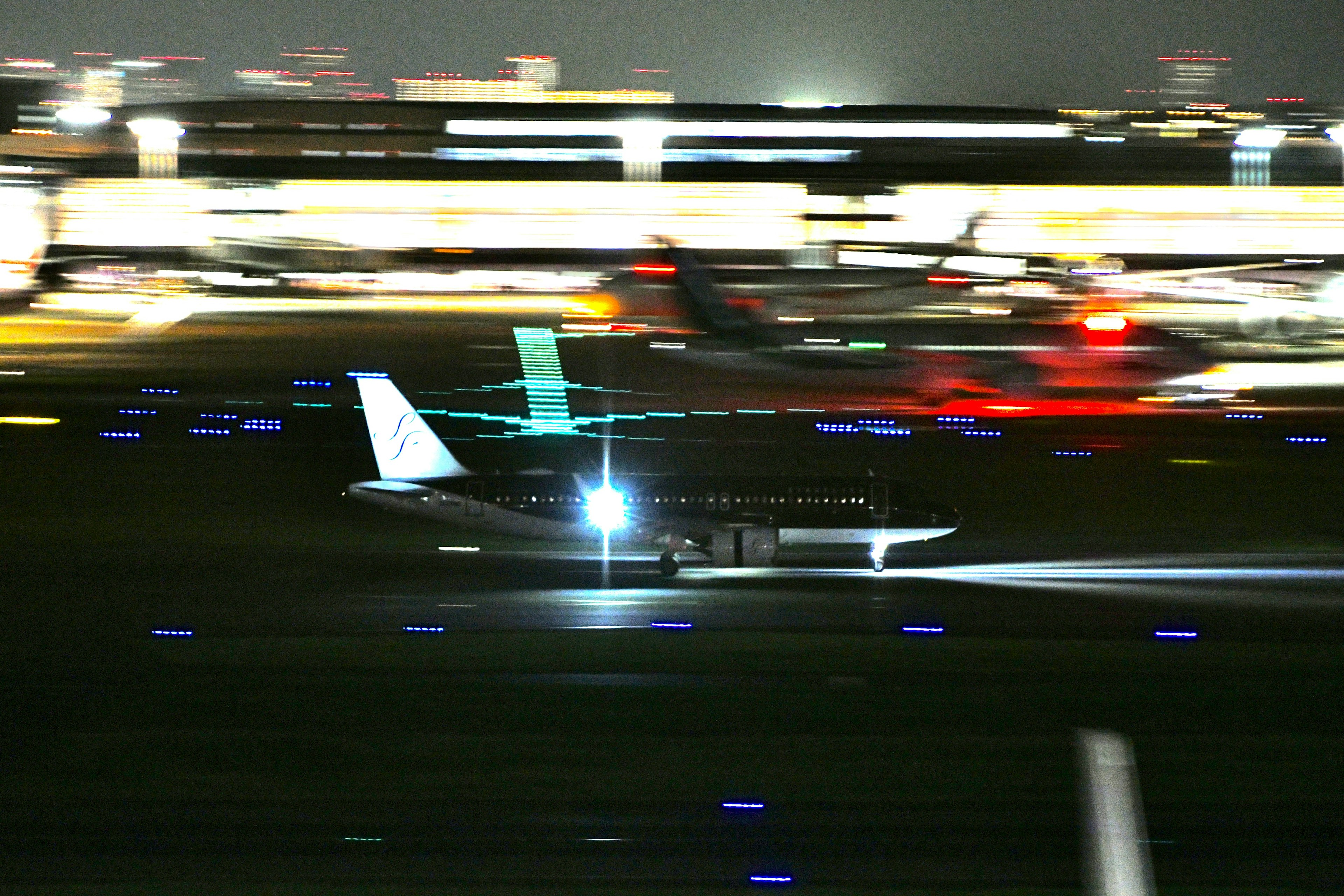 An airplane taking off at night with bright runway lights