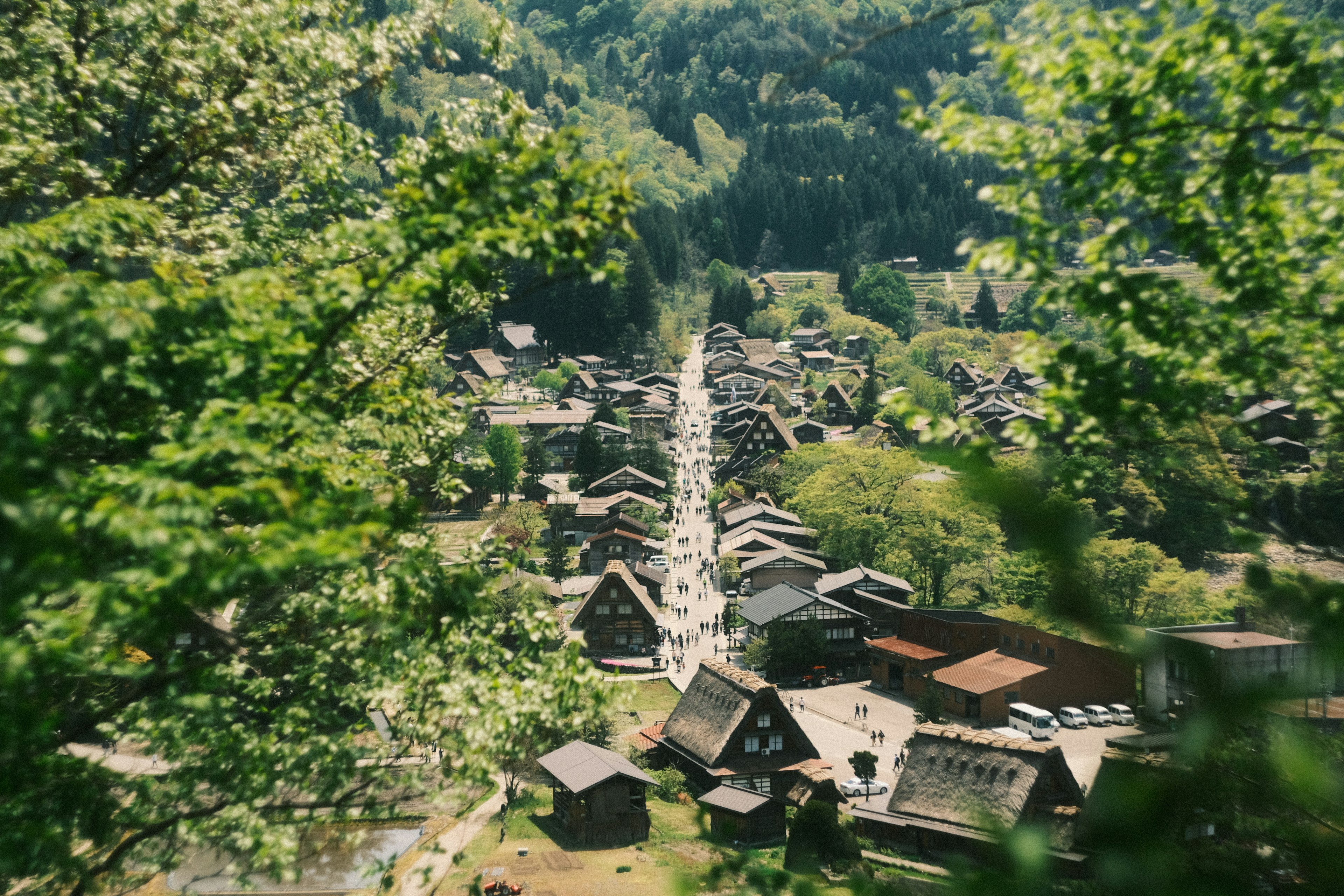 Scenic view of a village surrounded by lush mountains with traditional houses