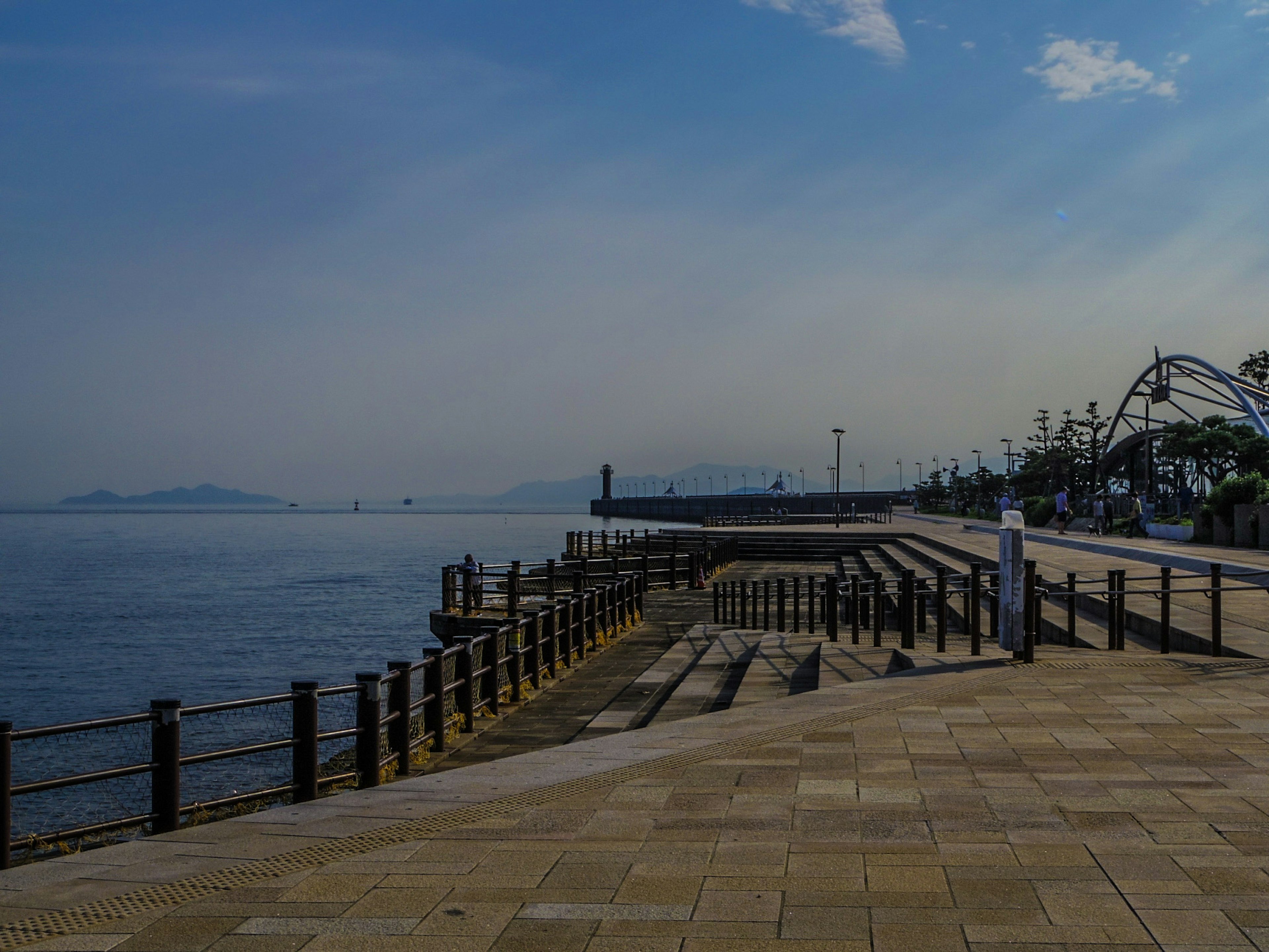 Paseo marítimo sereno con un muelle y aguas tranquilas