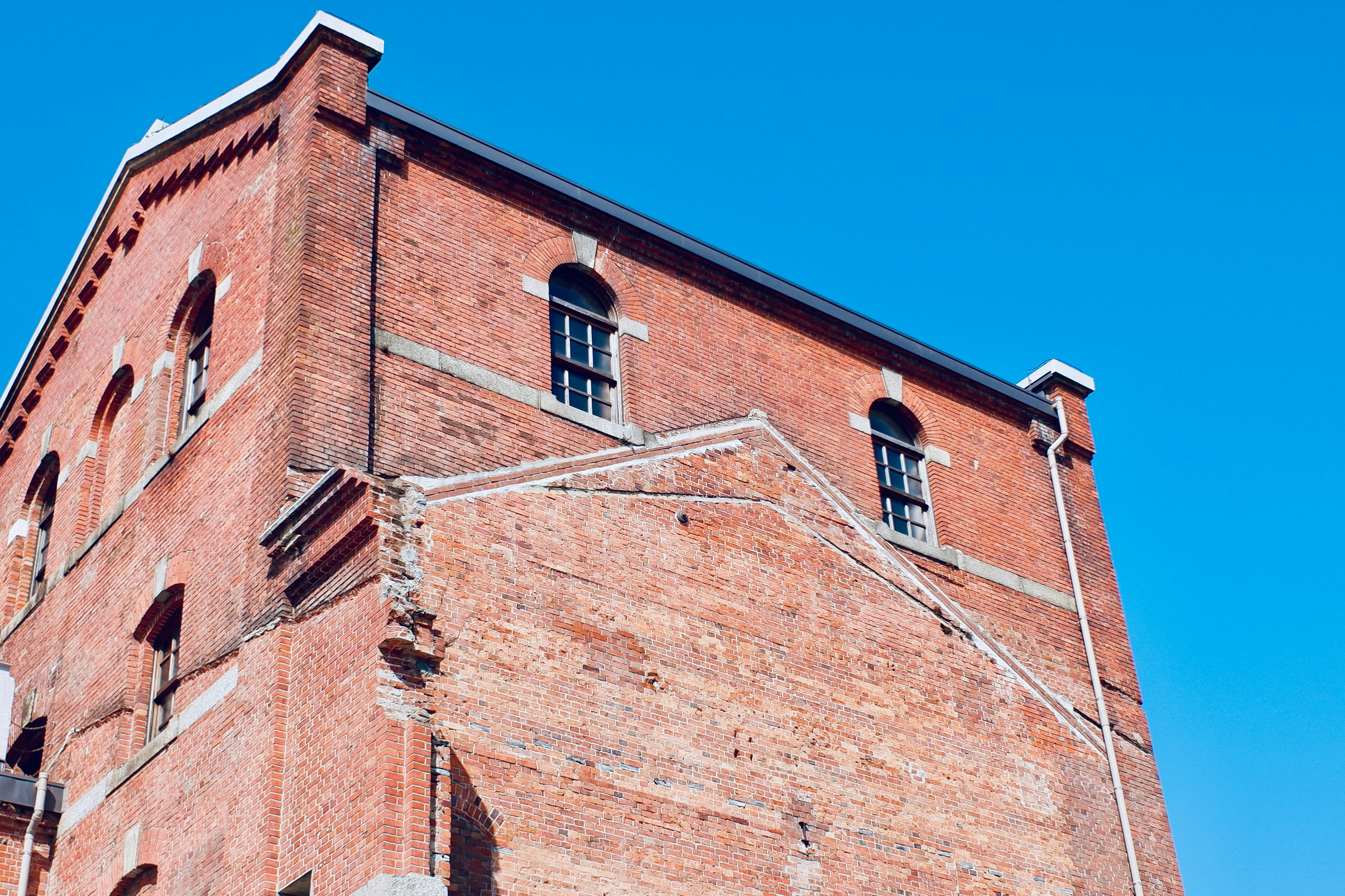 Coin d'un bâtiment en briques rouges sous un ciel bleu clair