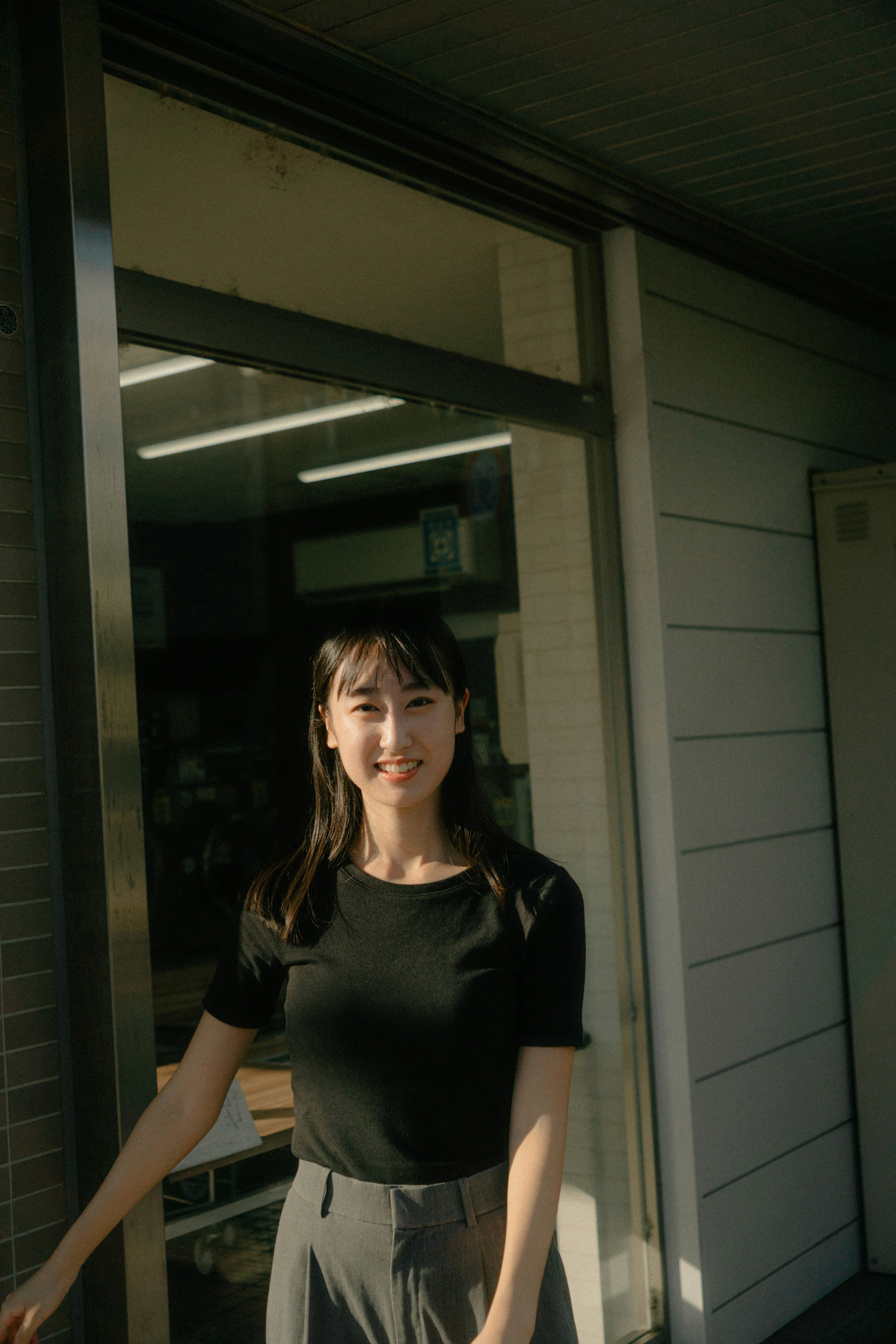 Una mujer sonriendo y posando frente a una ventana