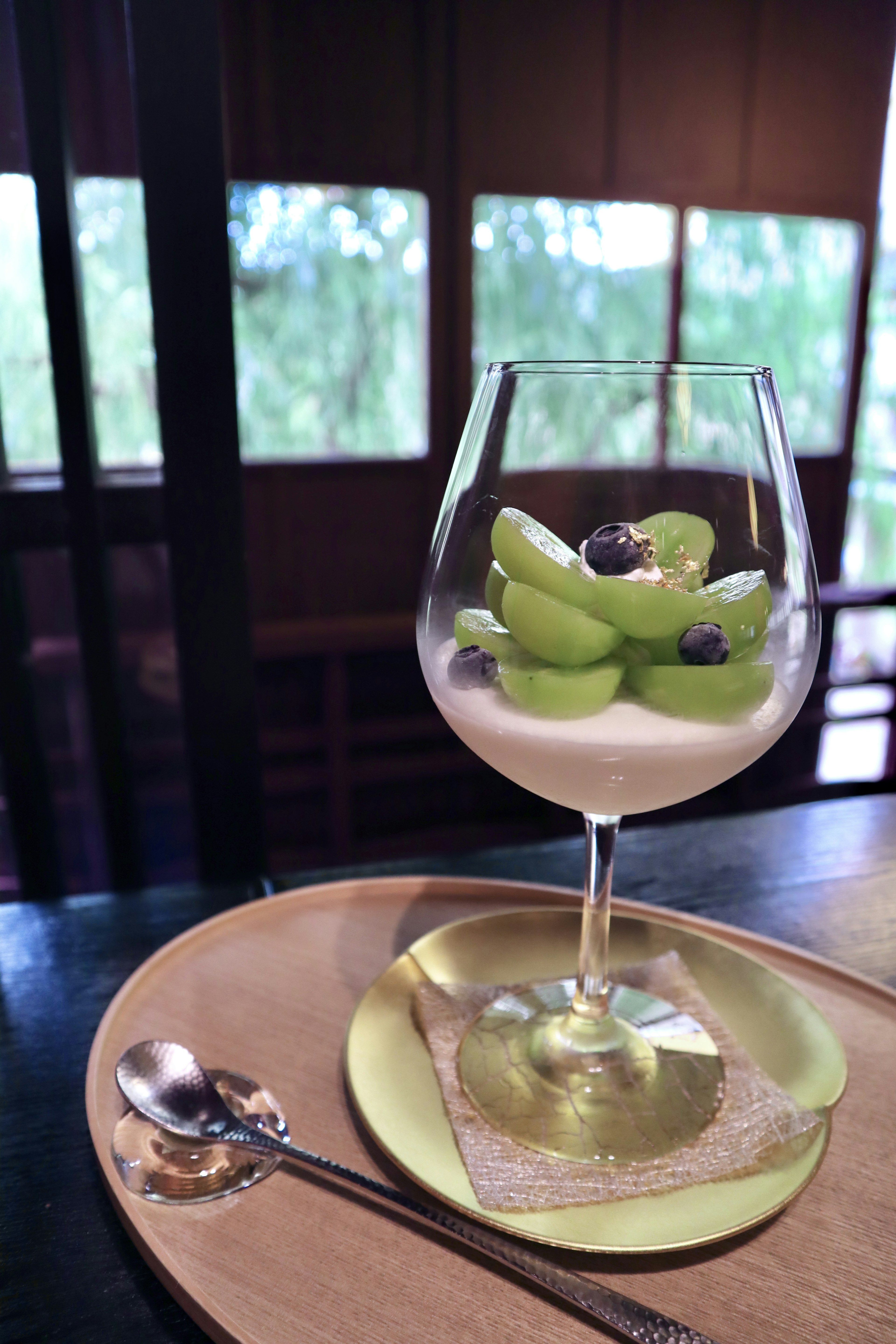 Dessert dans un bol en verre avec des raisins verts et des baies noires