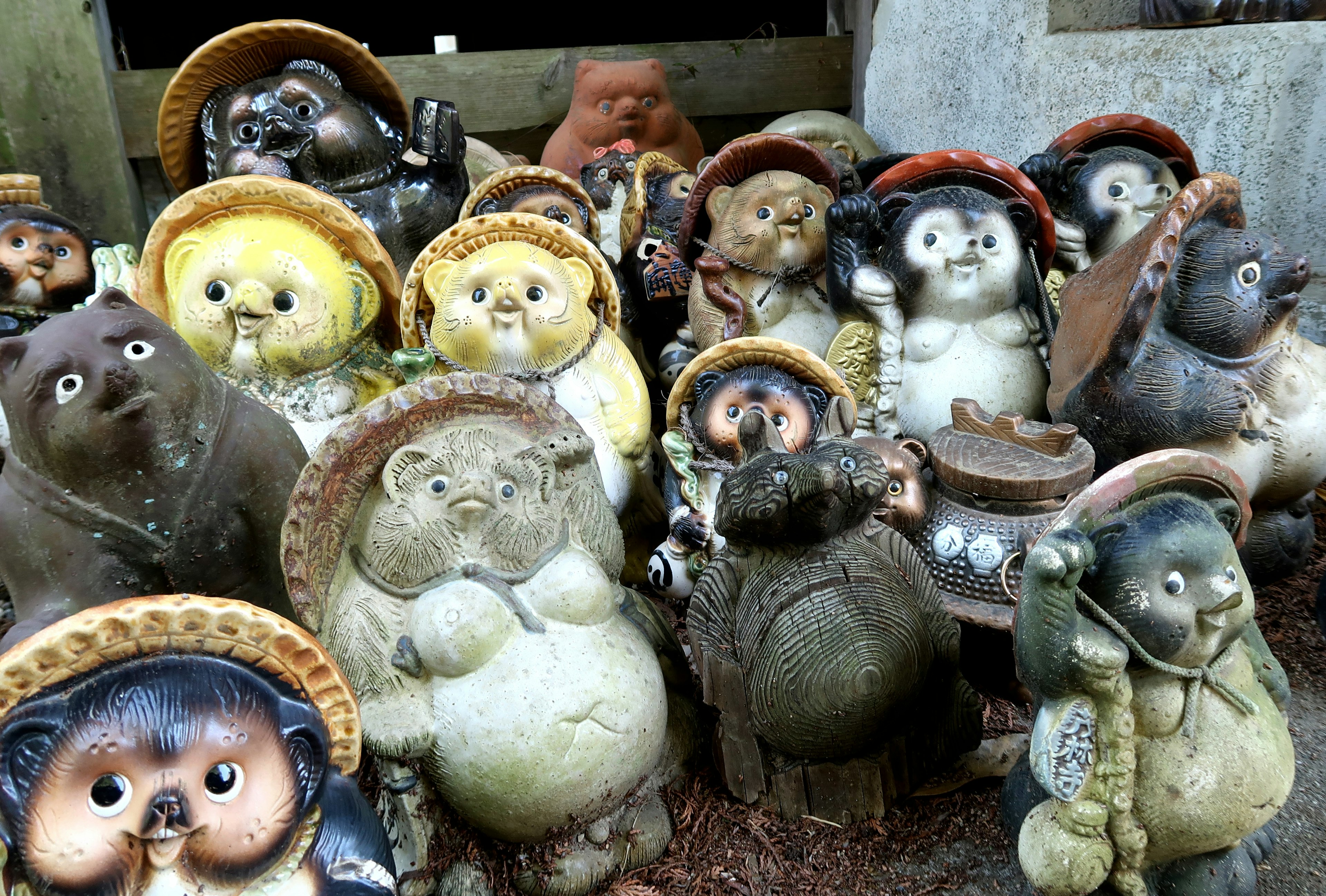 Una colección de figuras de tanuki con diferentes expresiones y sombreros