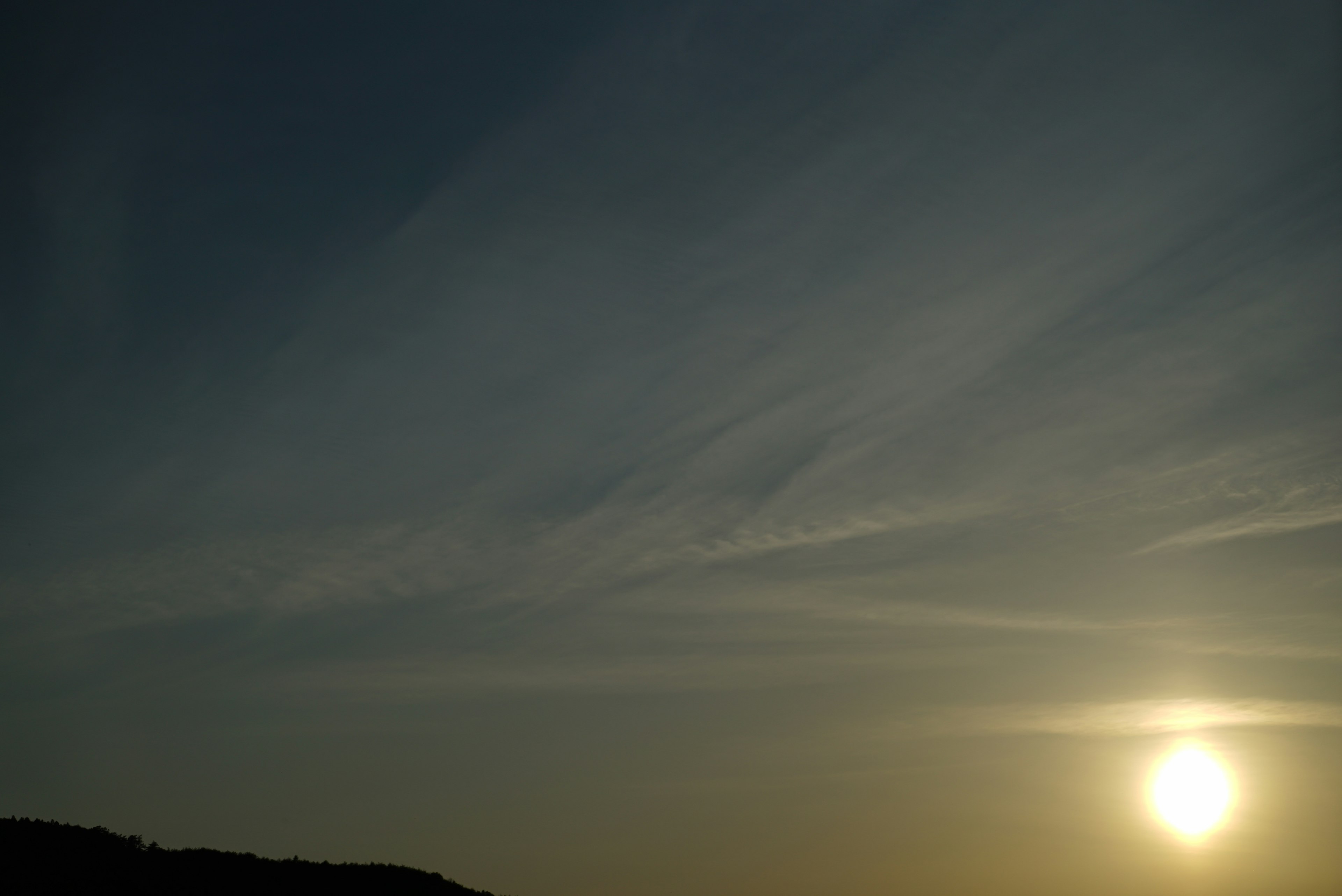 Coucher de soleil avec des nuages légers dans un ciel bleu