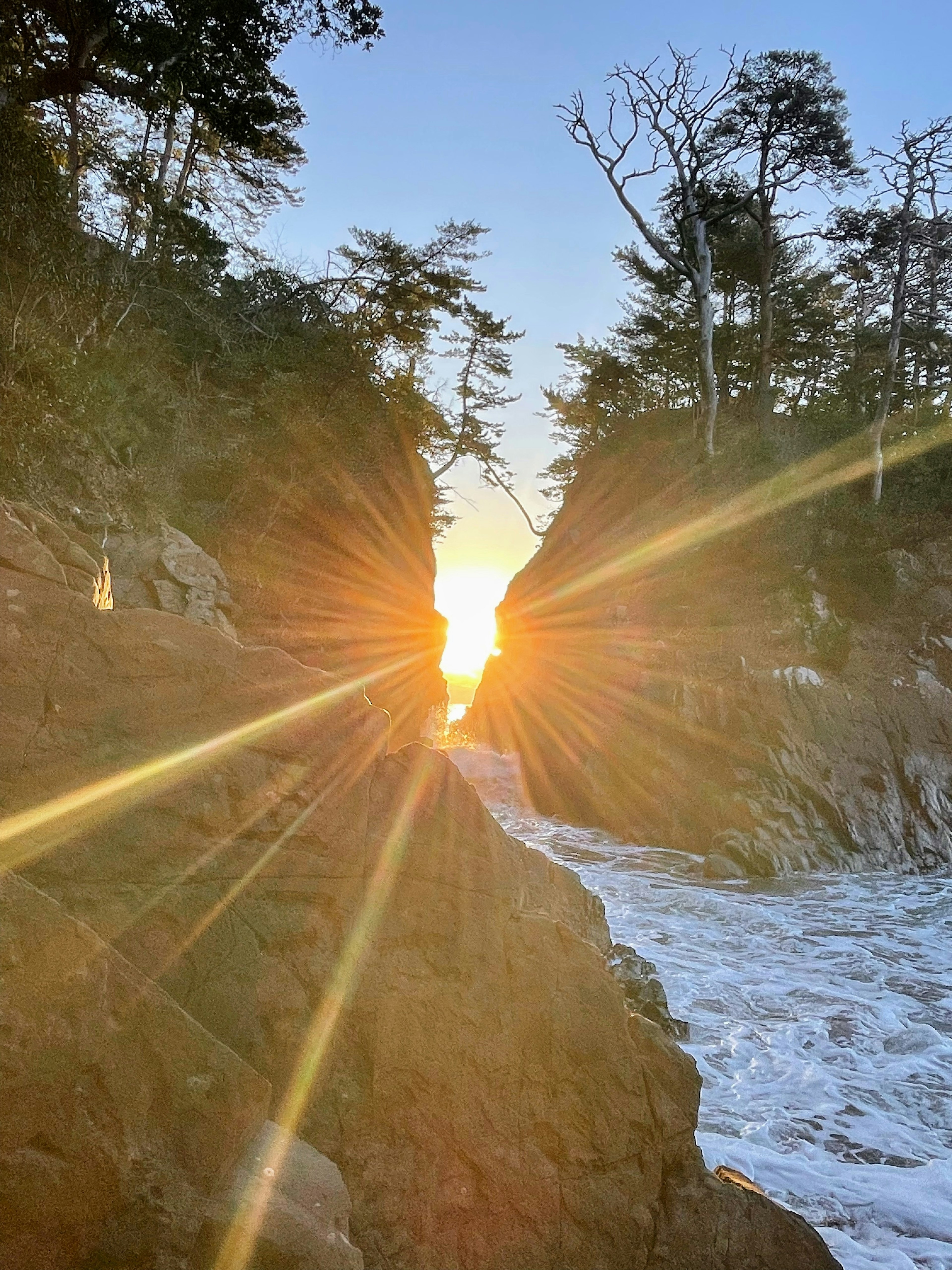 Schöne Küstenlandschaft mit Sonnenlicht, das durch die Felsen strahlt