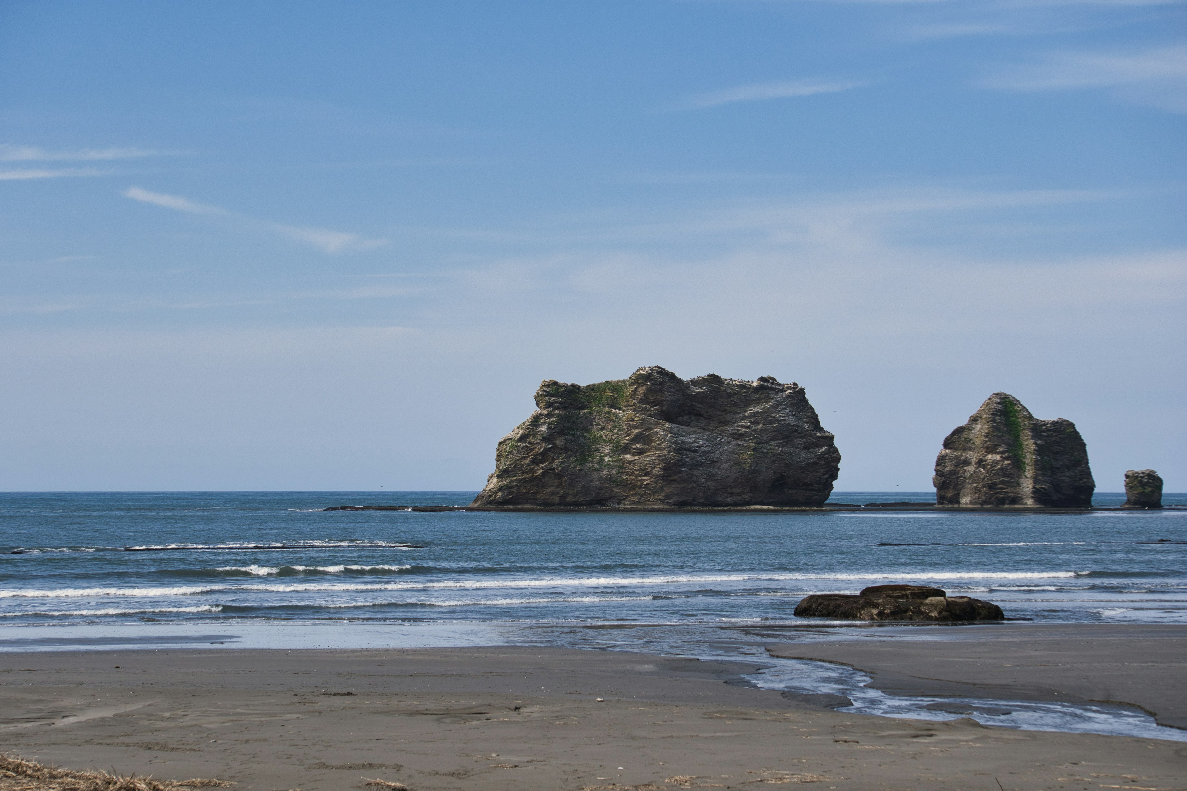 Rock formations in the ocean under a clear blue sky