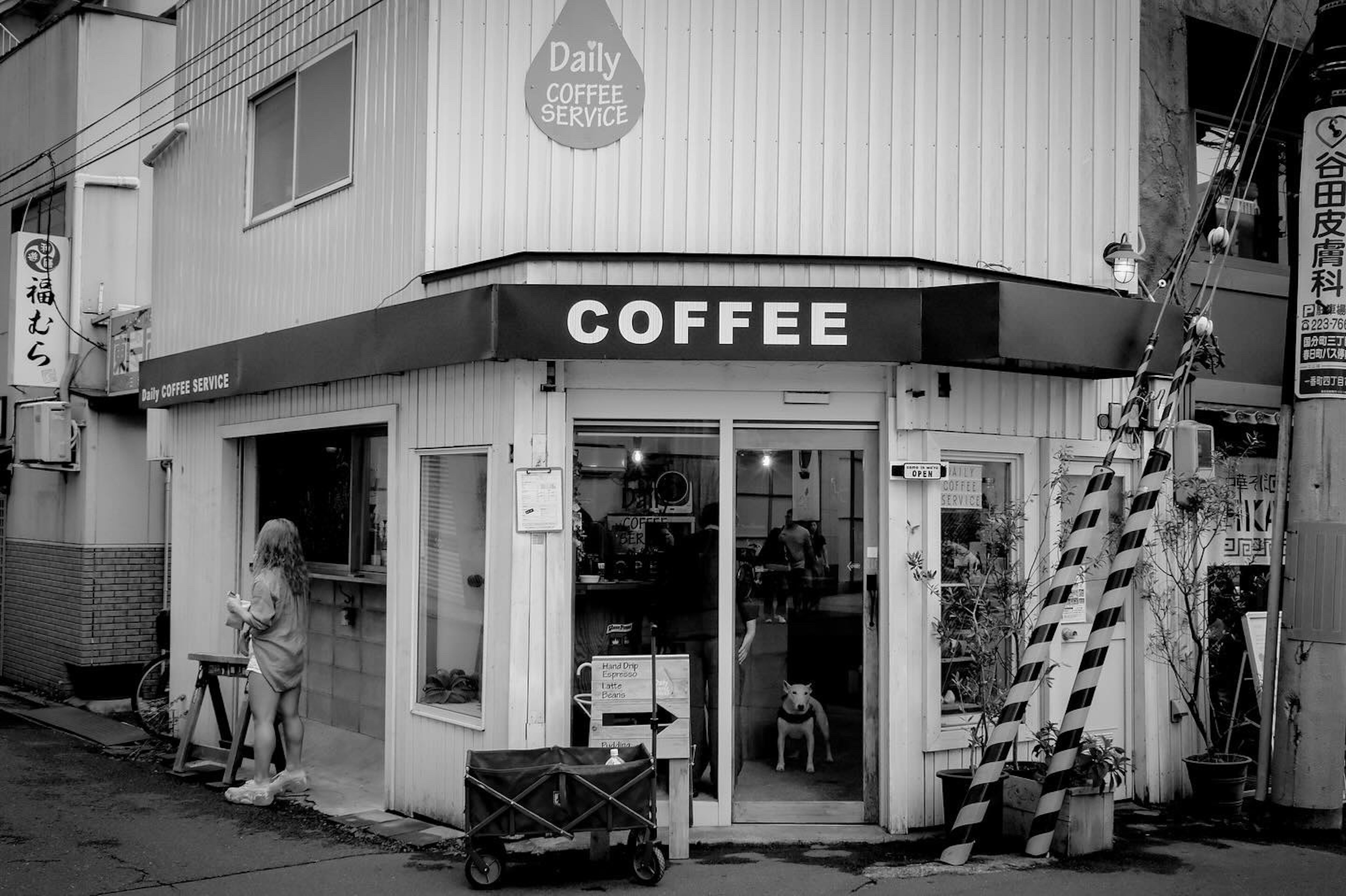 Außenansicht eines Cafés in Schwarz-Weiß mit einem stilvollen Schild