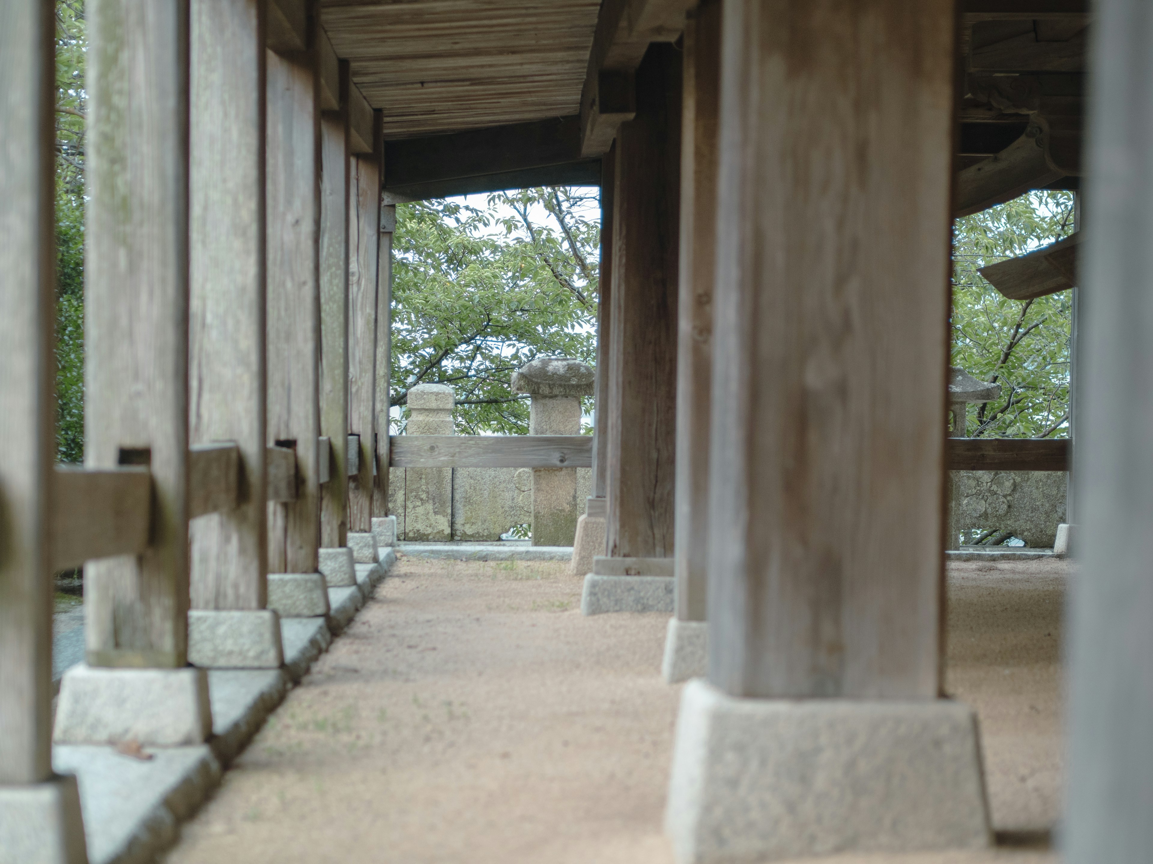 Interior view of a traditional building with wooden pillars and natural scenery