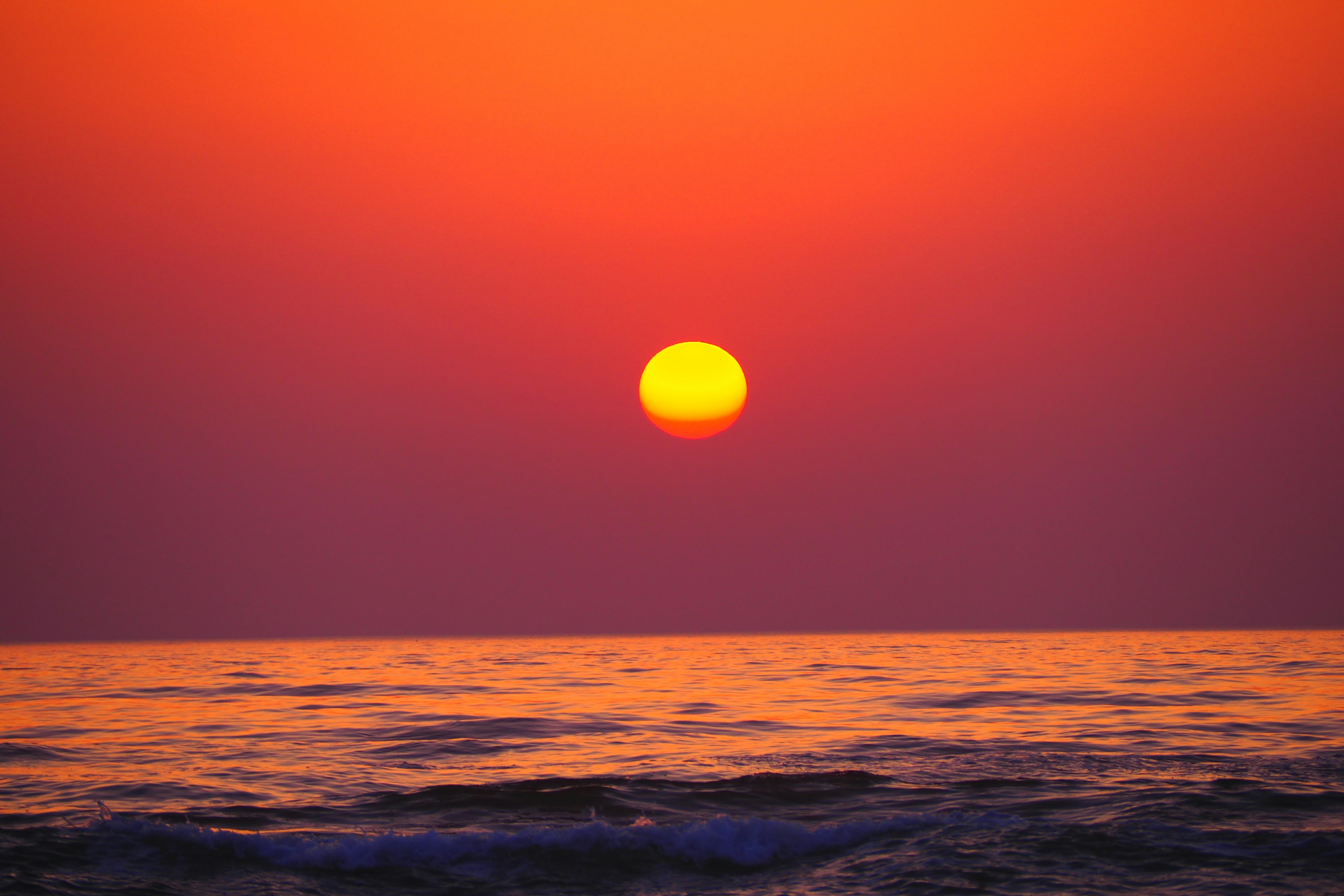 美しいオレンジ色の夕日が海の上に沈んでいる景色