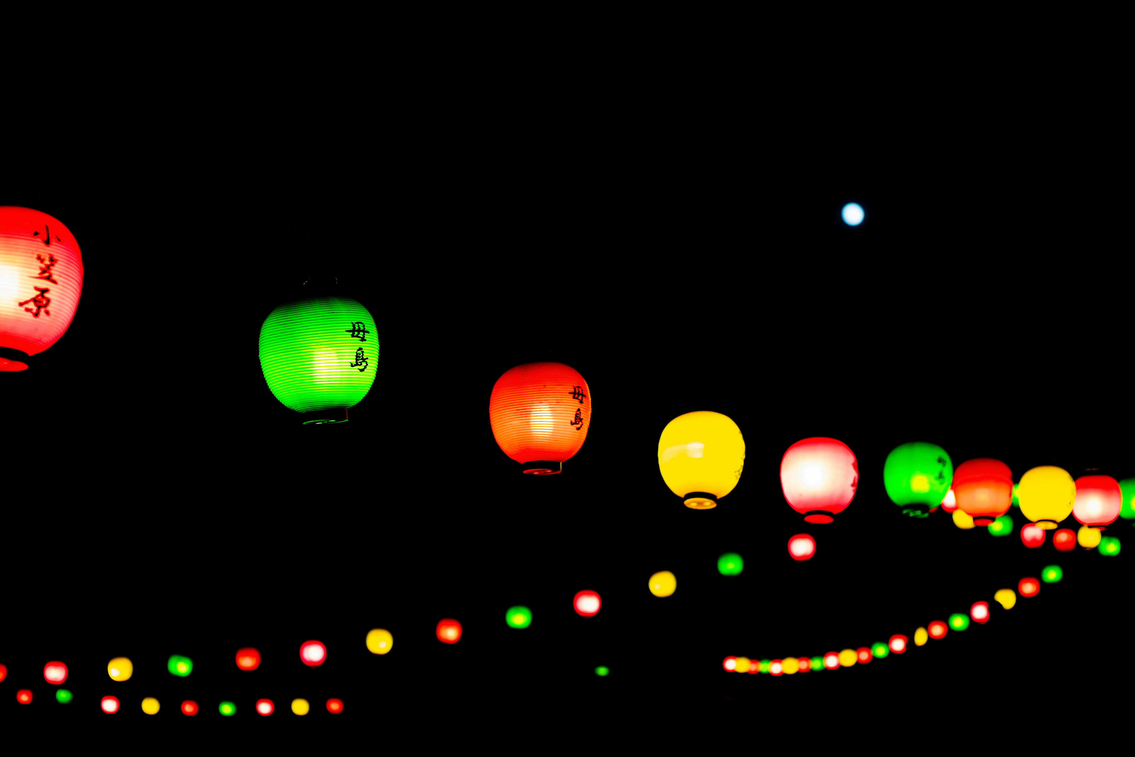 Colorful lanterns hanging against a dark night sky