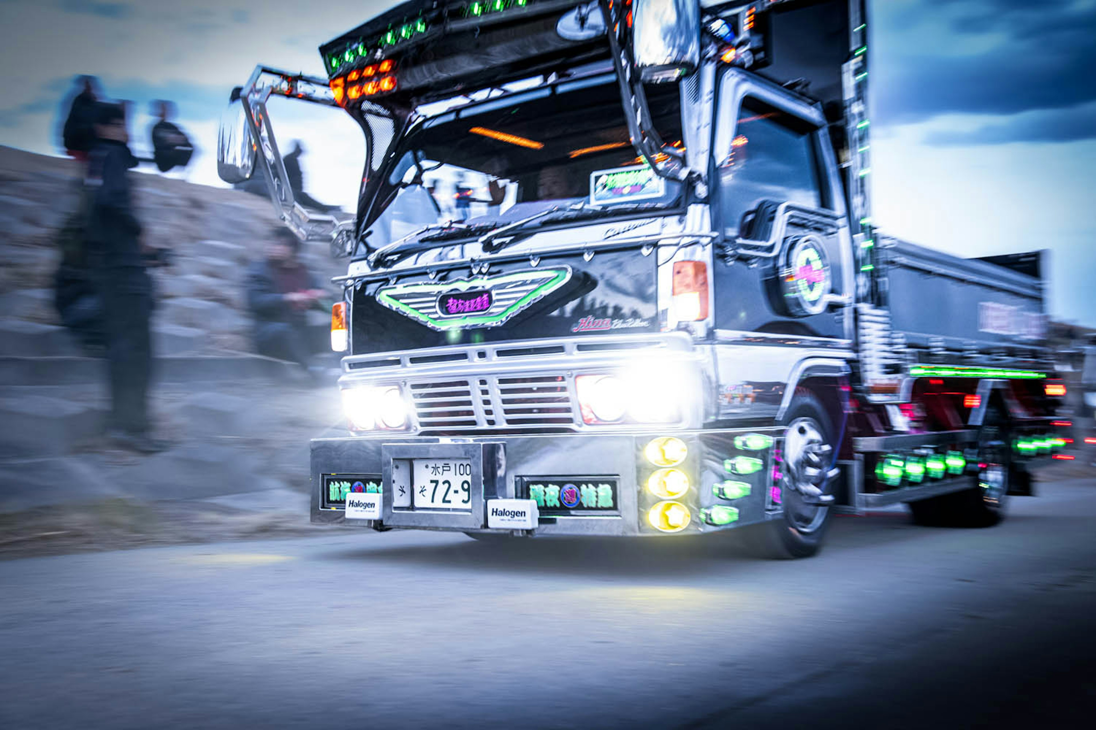 A brightly lit truck with colorful LED lights driving on the road