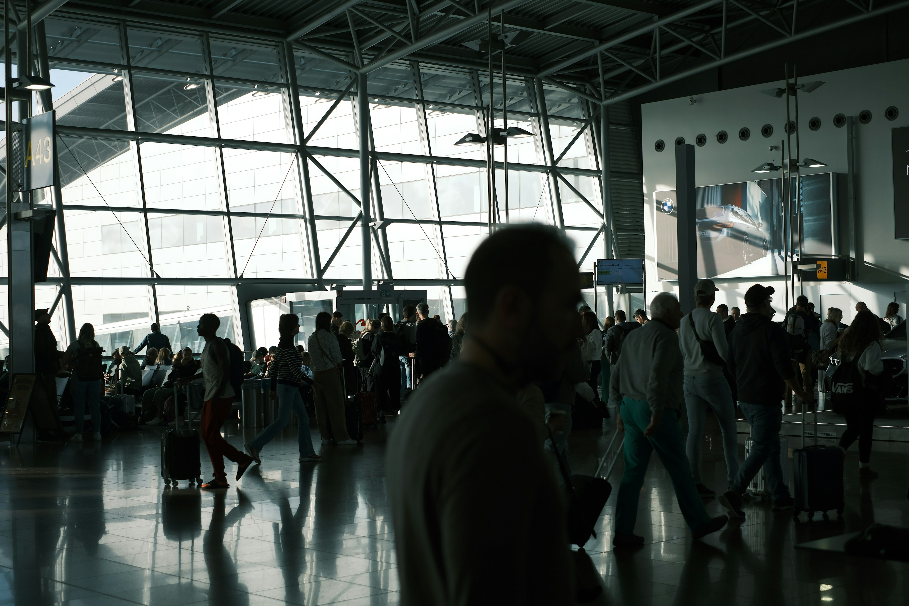 Belebter Flughafen mit Reisenden und großen Glasfenstern